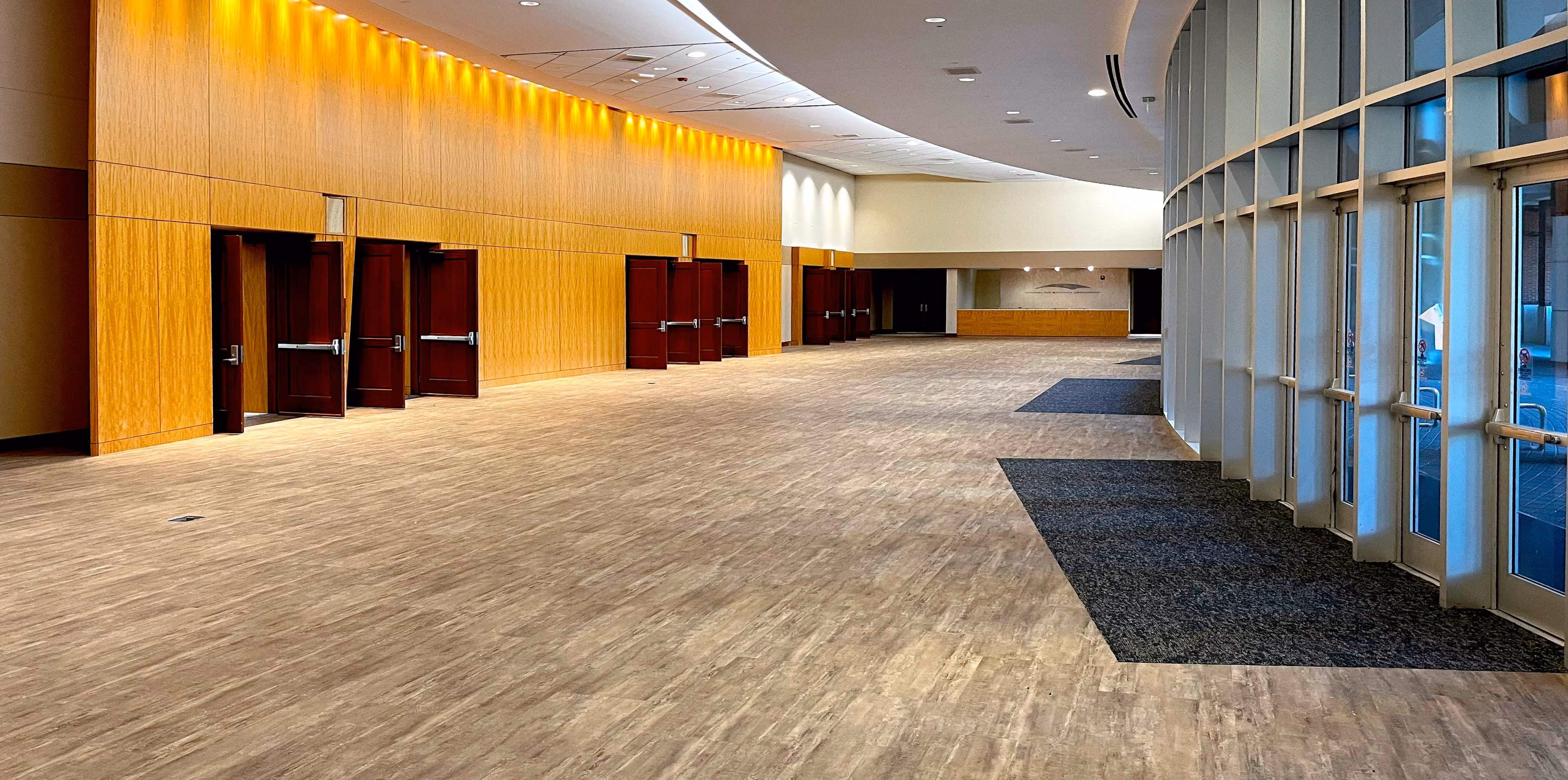 School hallway with lockers and light speckled tile flooring