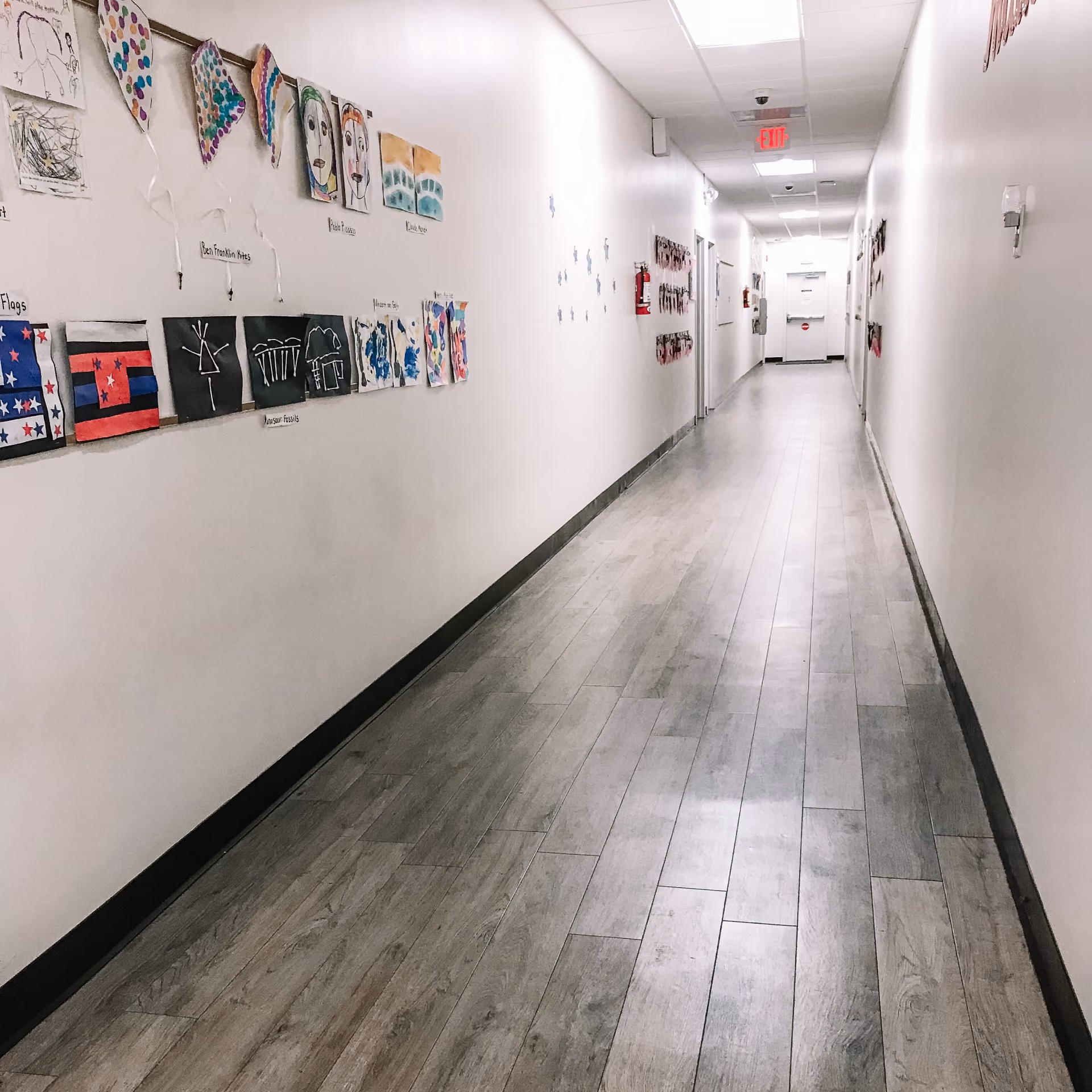 School hallway with bulletin boards and light gray flooring