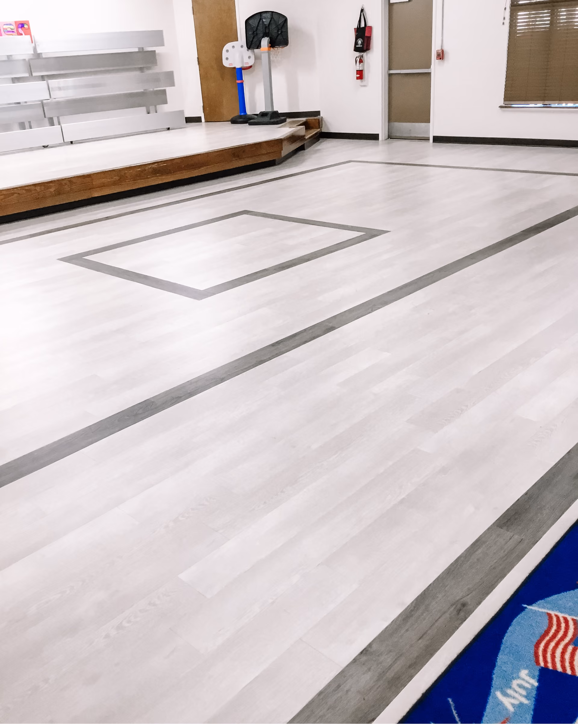 School hallway with light gray flooring and a yellow accent wall
