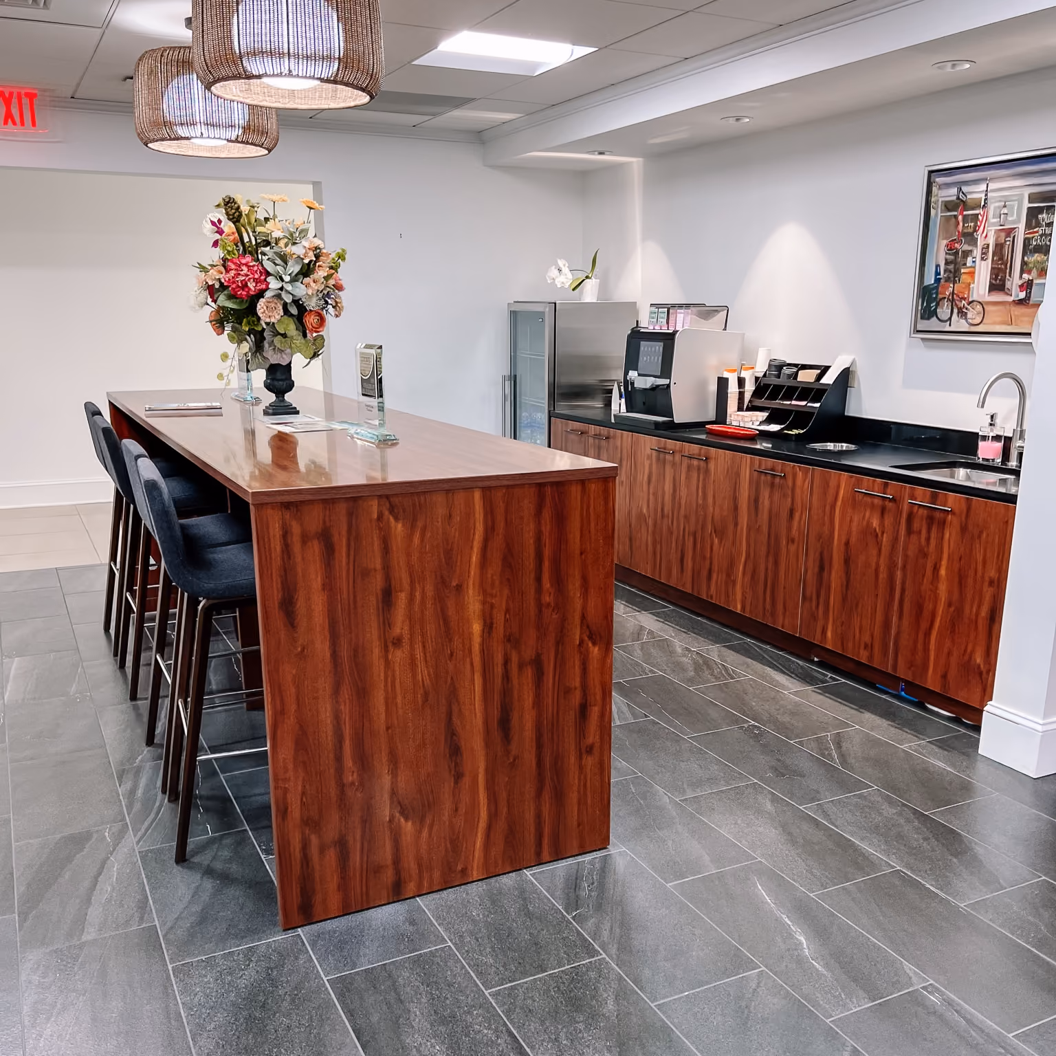 Dealership customer lounge with a wood accent reception counter and light wood-look flooring