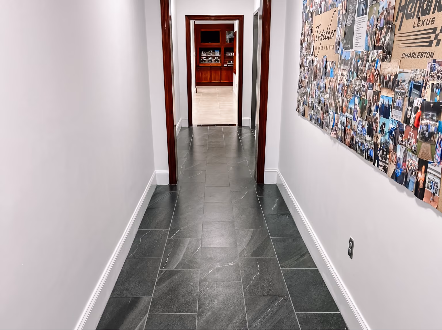 Dealership hallway with dark polished flooring and framed artwork