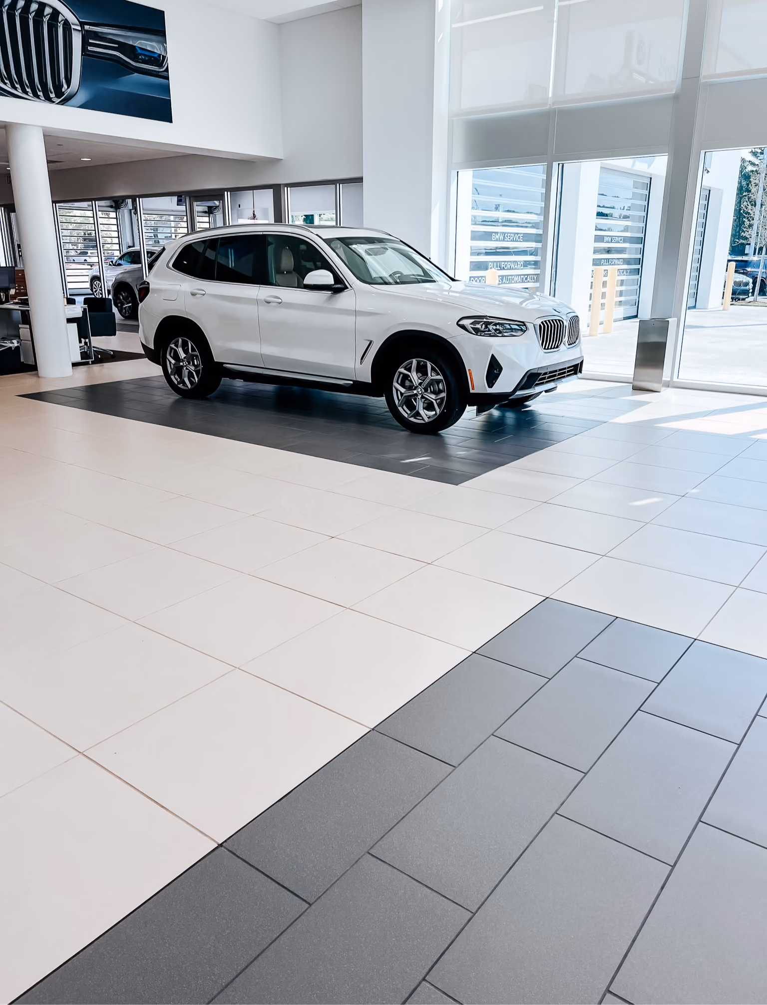 Dealership showroom floor with a vehicle parked on light tile flooring