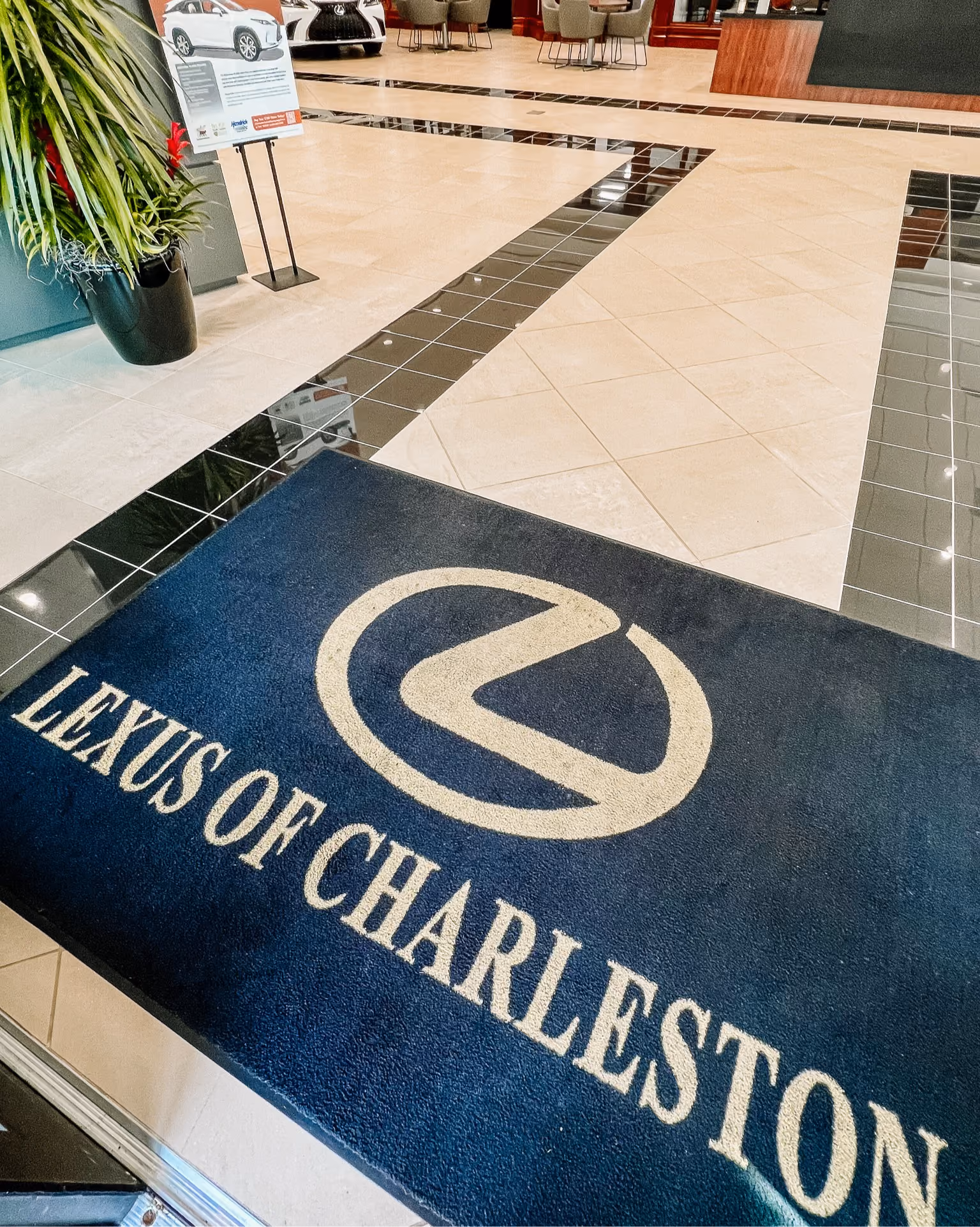 Dealership entrance mat with a logo inset into dark polished flooring