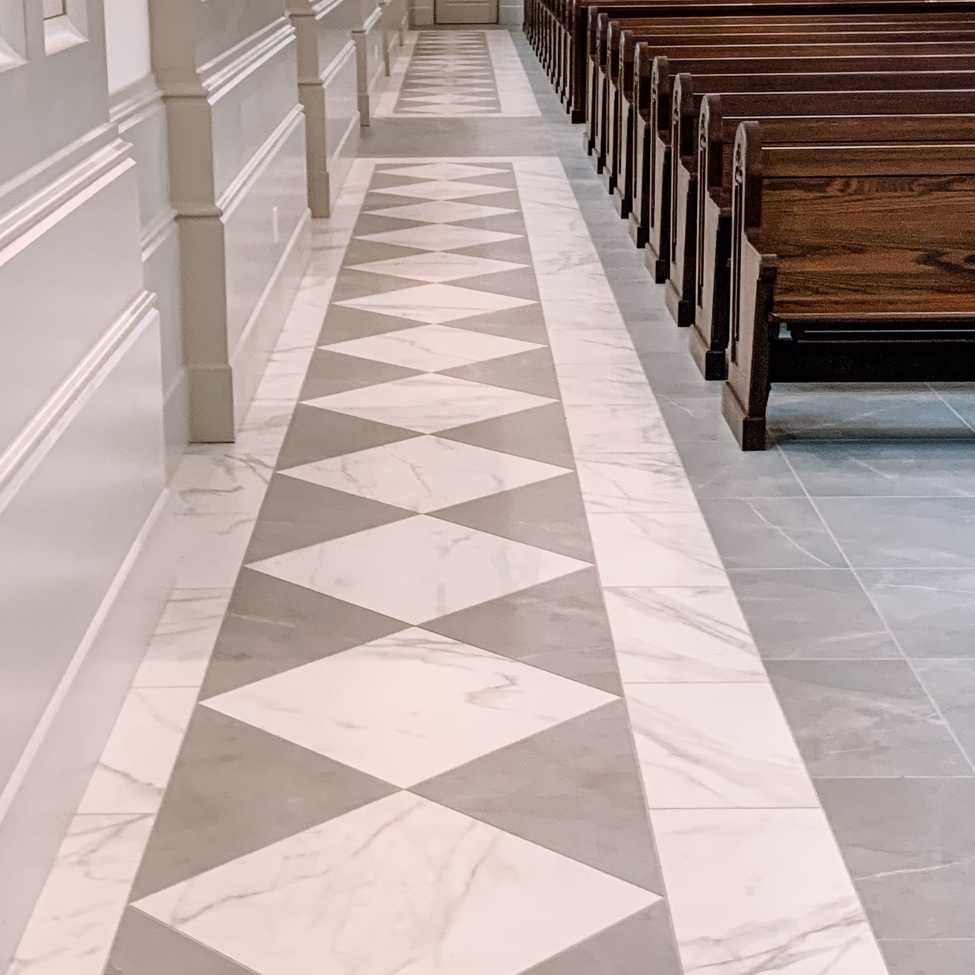 Church aisle with diamond-pattern checkerboard flooring and wood pews