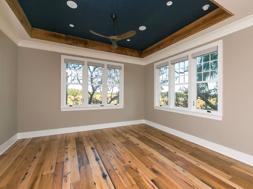 New construction living room with large windows and hardwood flooring