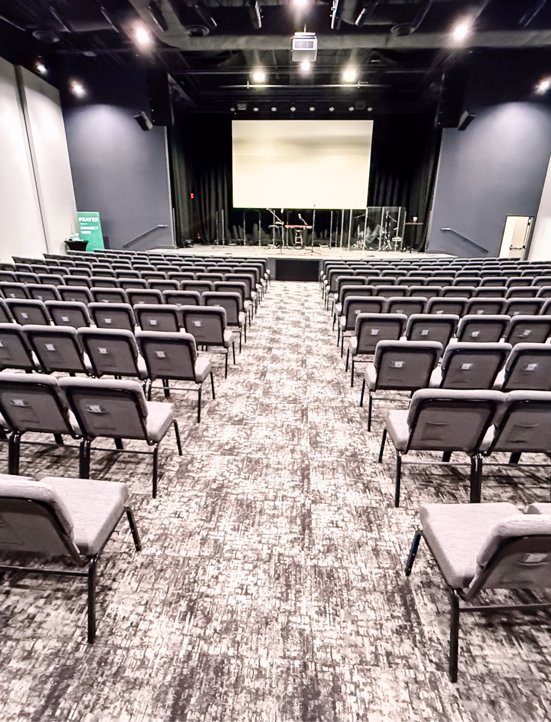 Church fellowship hall set up with round tables and patterned carpet flooring