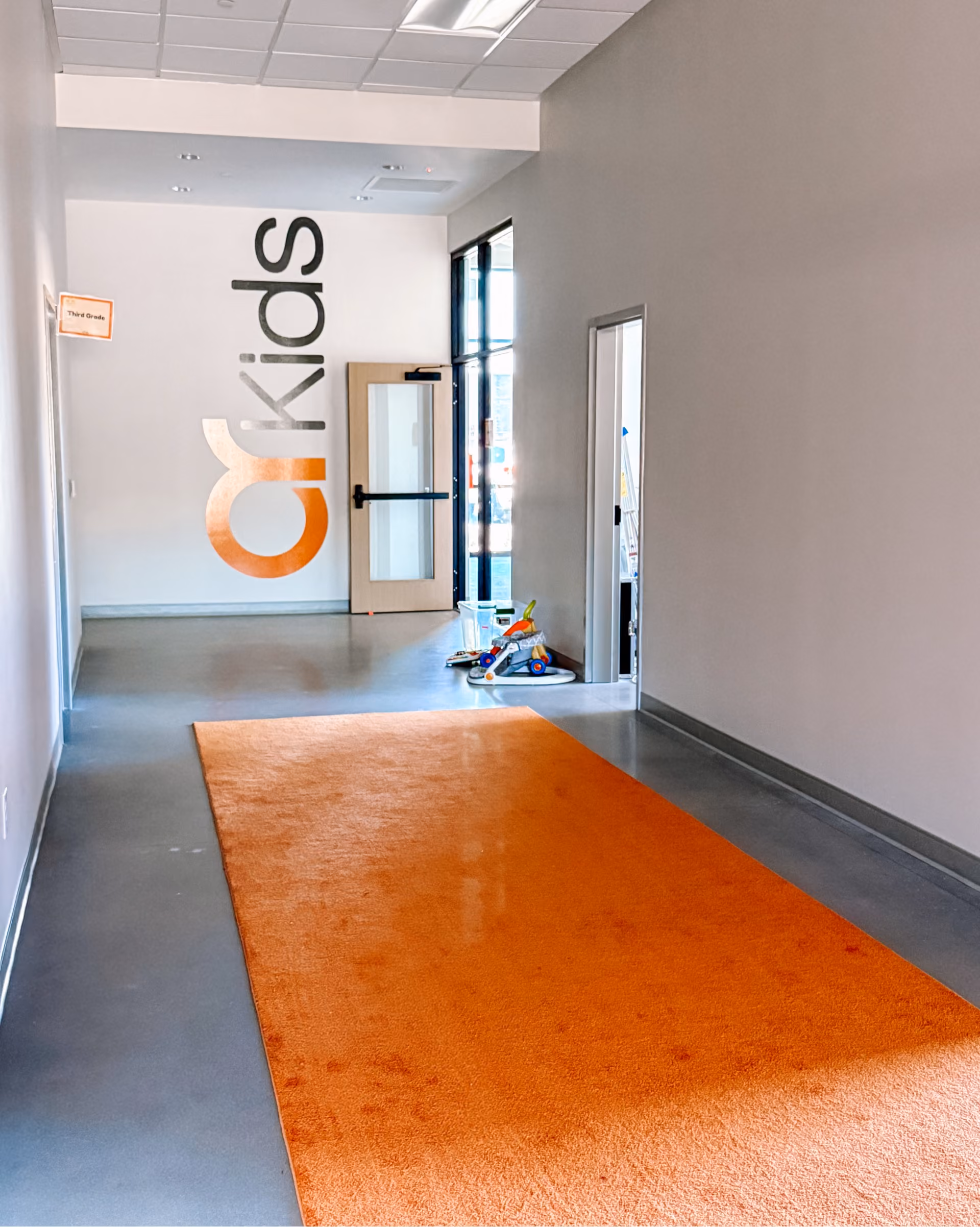 Church entrance vestibule with an orange accent rug and light tile flooring