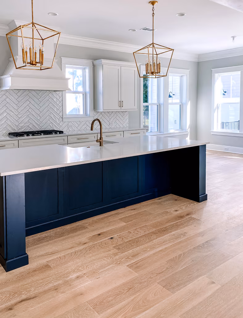 New construction kitchen with navy cabinetry, a herringbone tile backsplash, and hardwood flooring