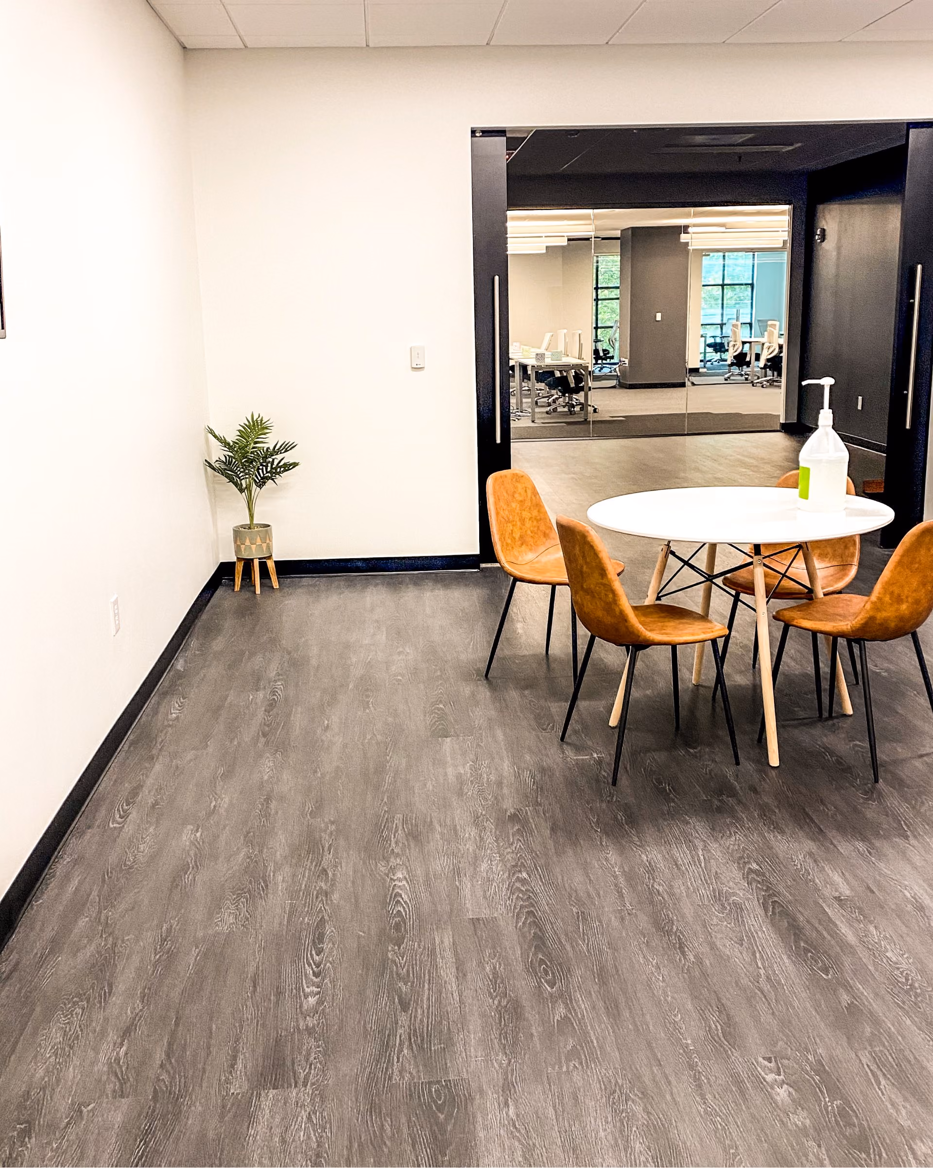 Office breakroom with a round table, chairs, and patterned commercial carpet flooring