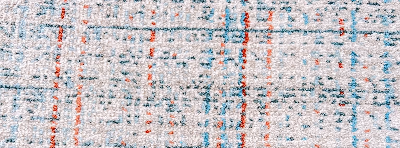 Close-up of a red, white, and blue patterned commercial carpet tile