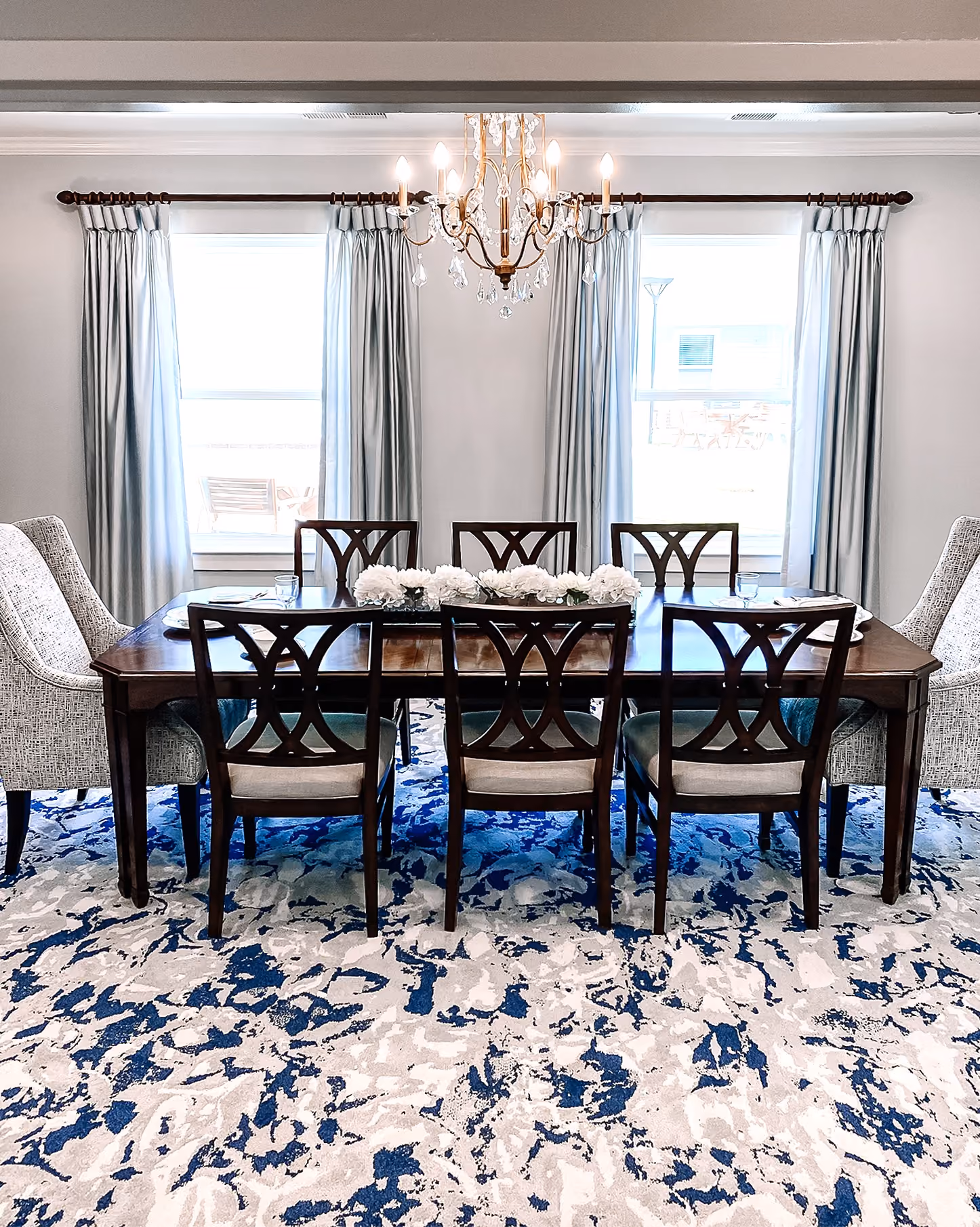 Senior living dining room with a blue patterned carpet and dining set