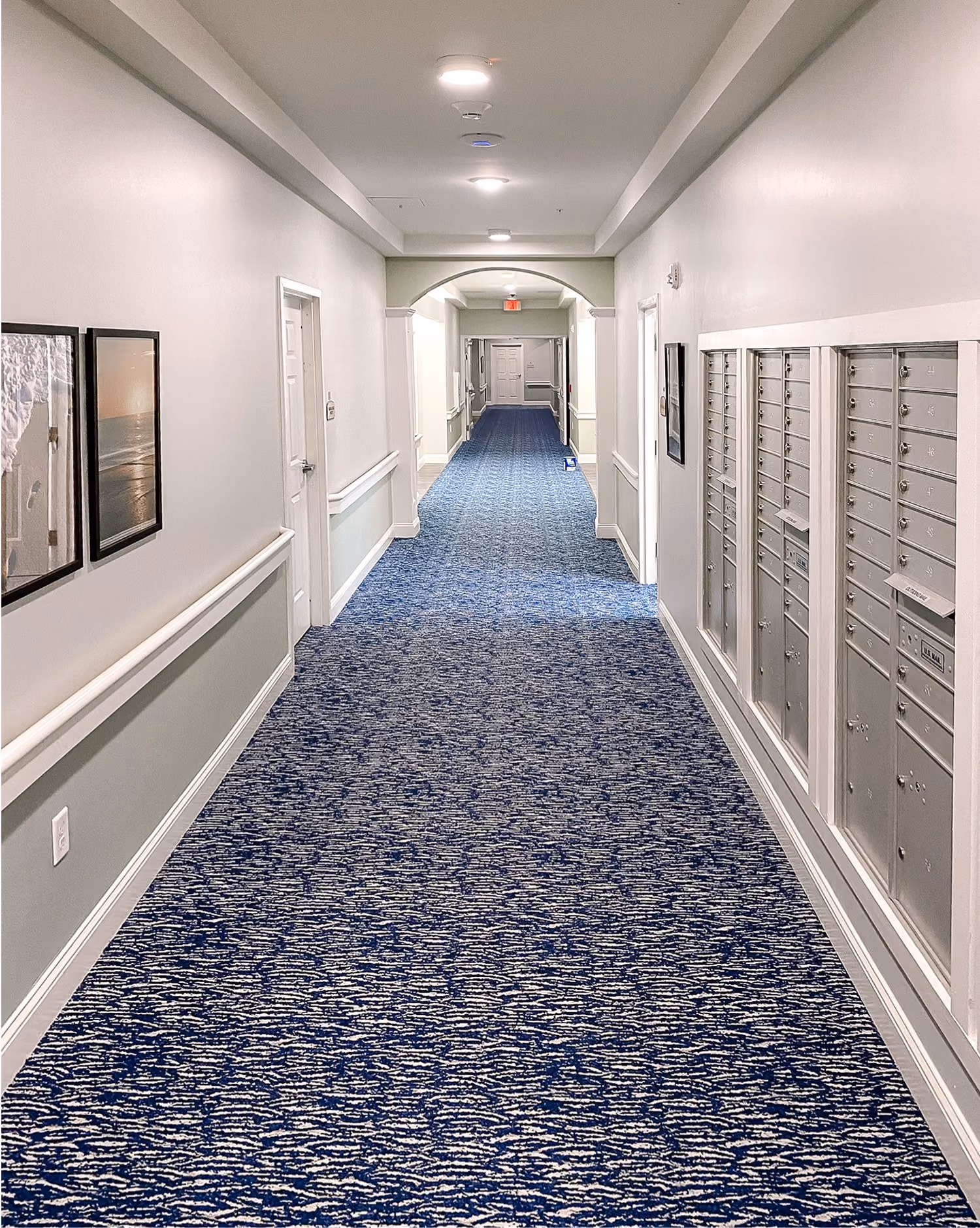 Senior living hallway with a blue speckled carpet runner