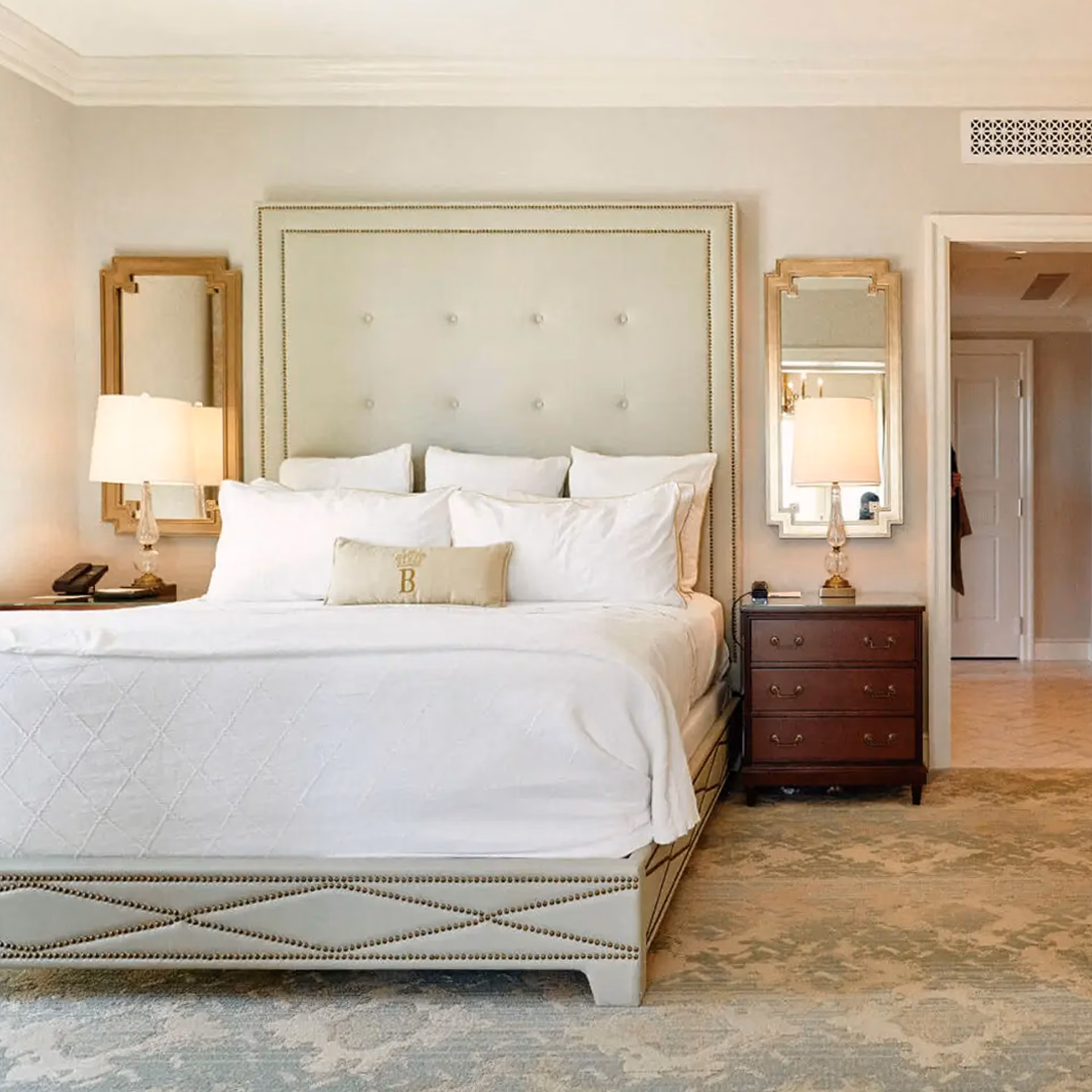 Hotel guest room with a made bed and wood-look flooring