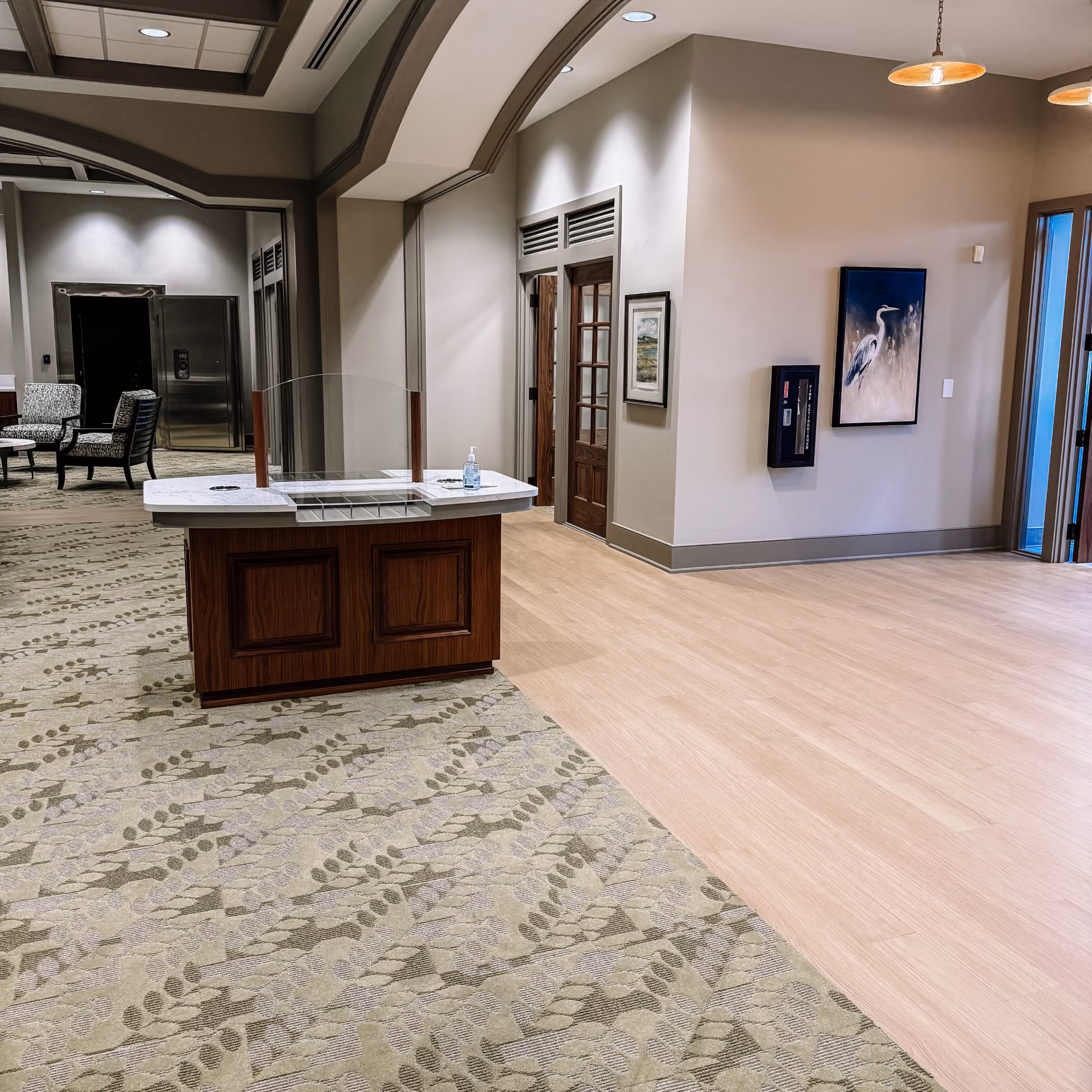 Bank lobby with a teller counter and speckled carpet flooring