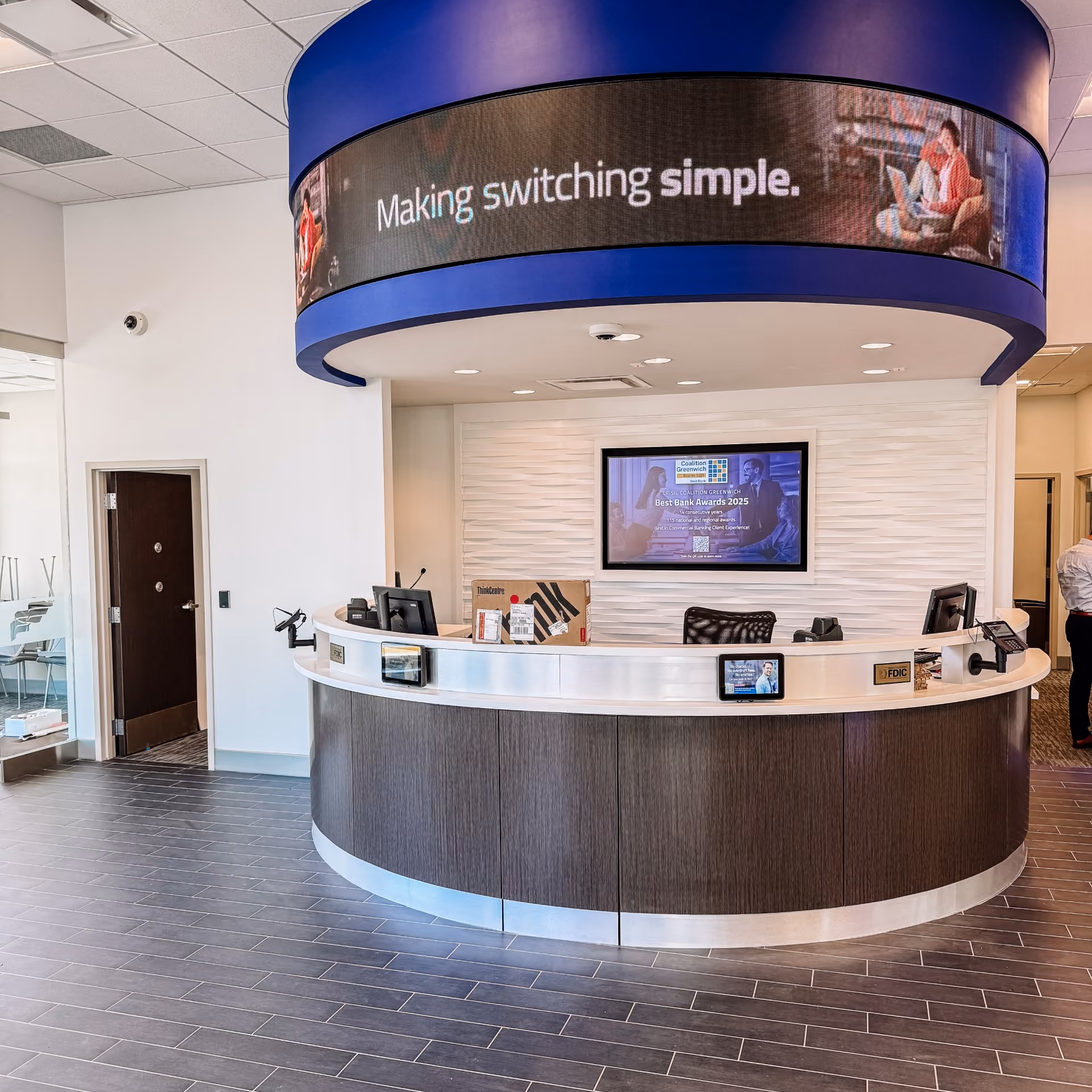 Bank lobby with a reception desk and speckled carpet flooring