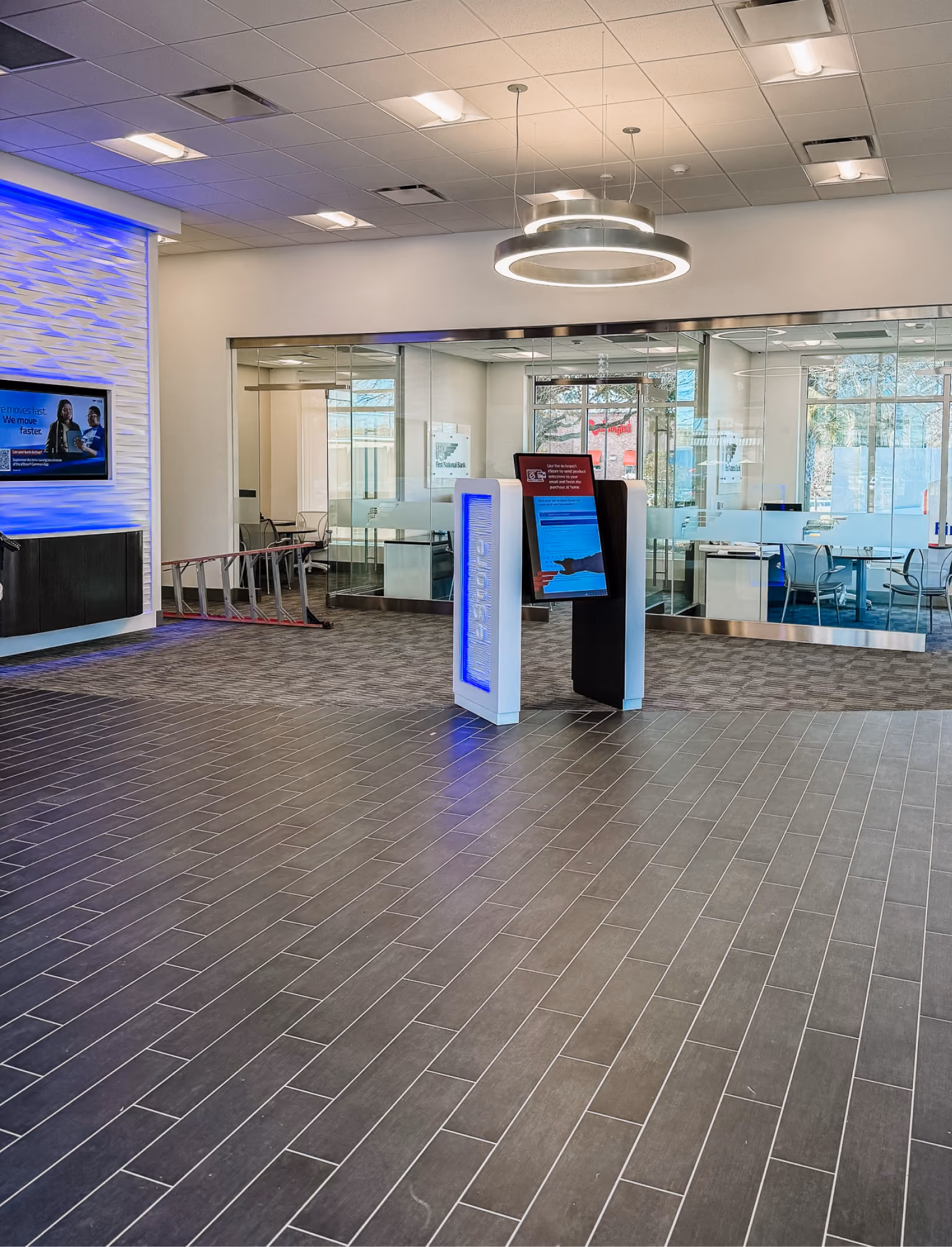 Bank branch interior with an ATM kiosk and speckled tile flooring