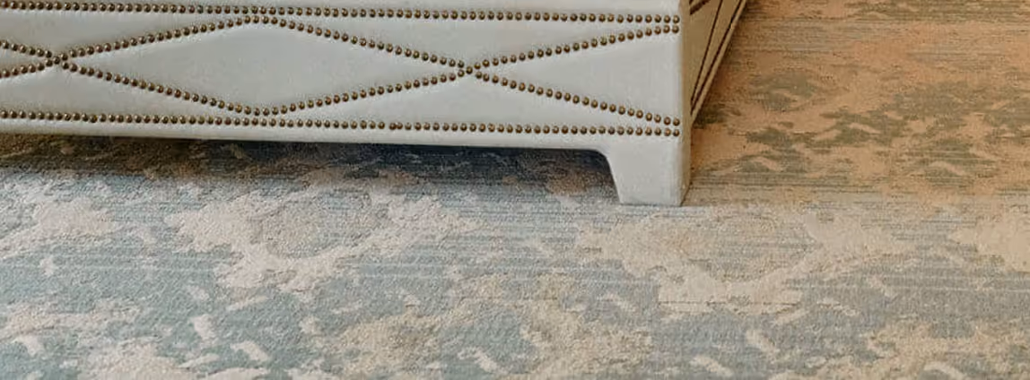 Close-up of a blue-gray patterned area rug on hardwood flooring
