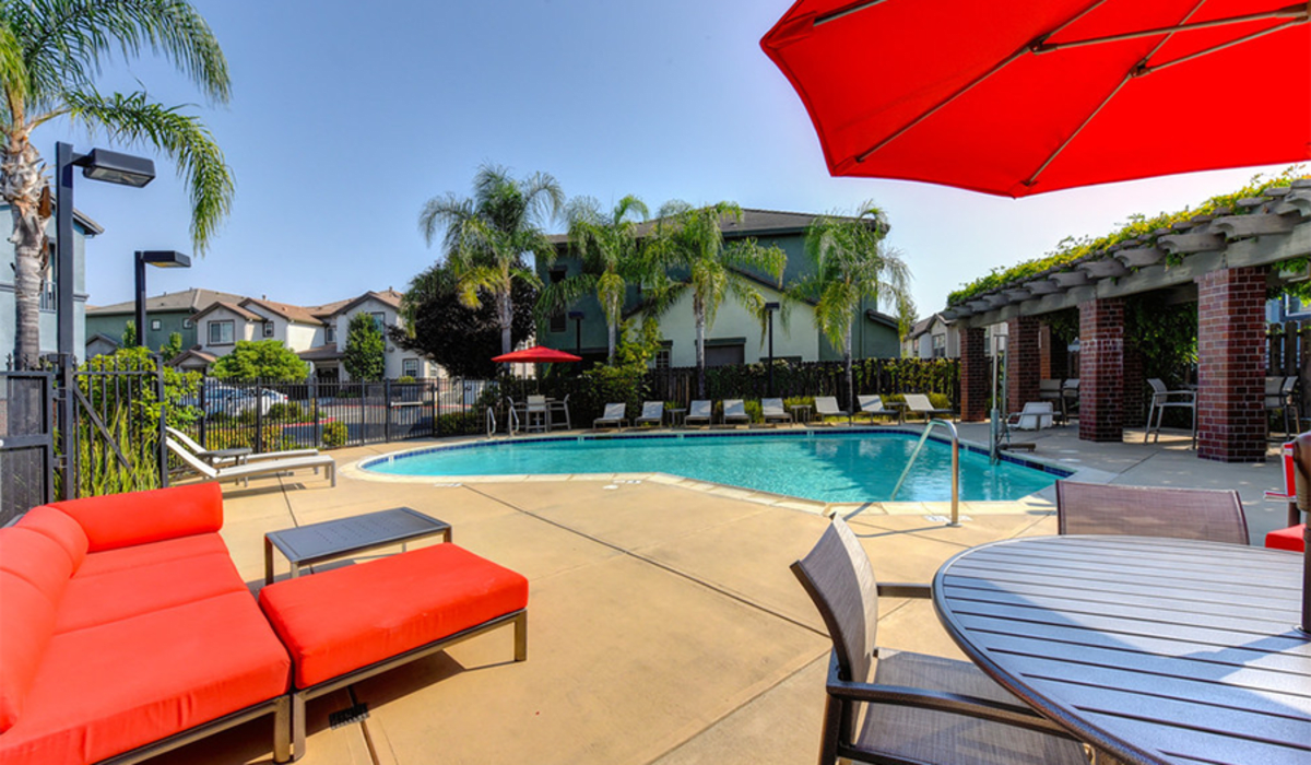 Pool with tables and chairs with umbrellas