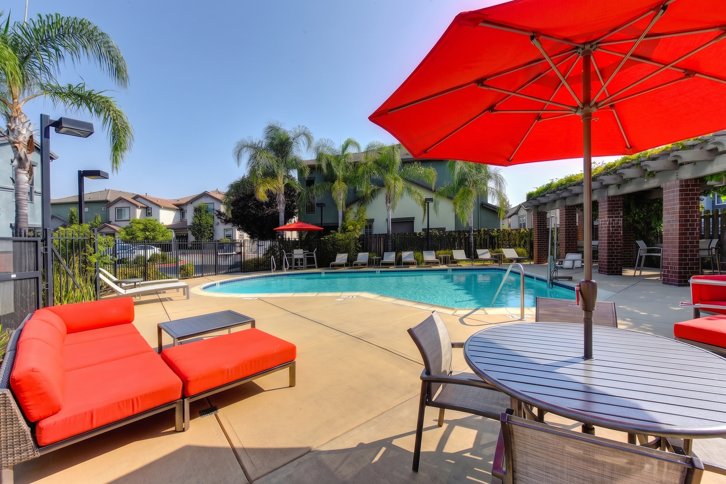Inground pool with lounge chairs and table with umbrella