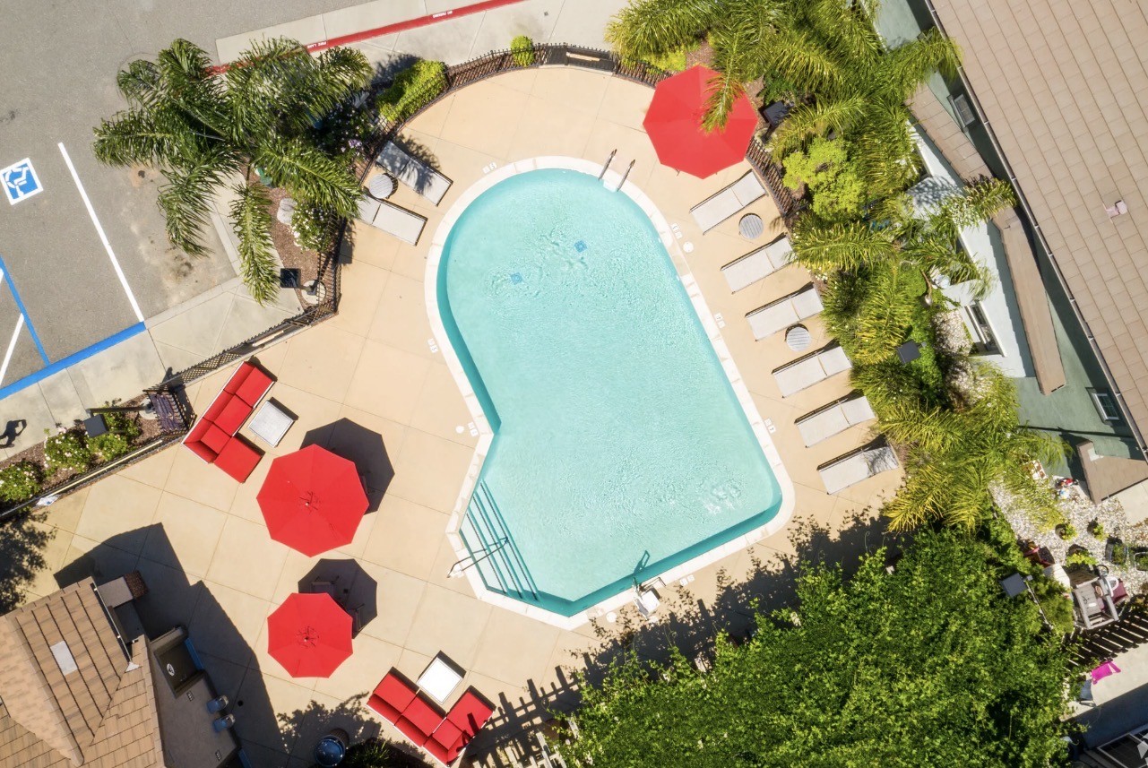 Pool with lounge chairs and tables with umbrellas