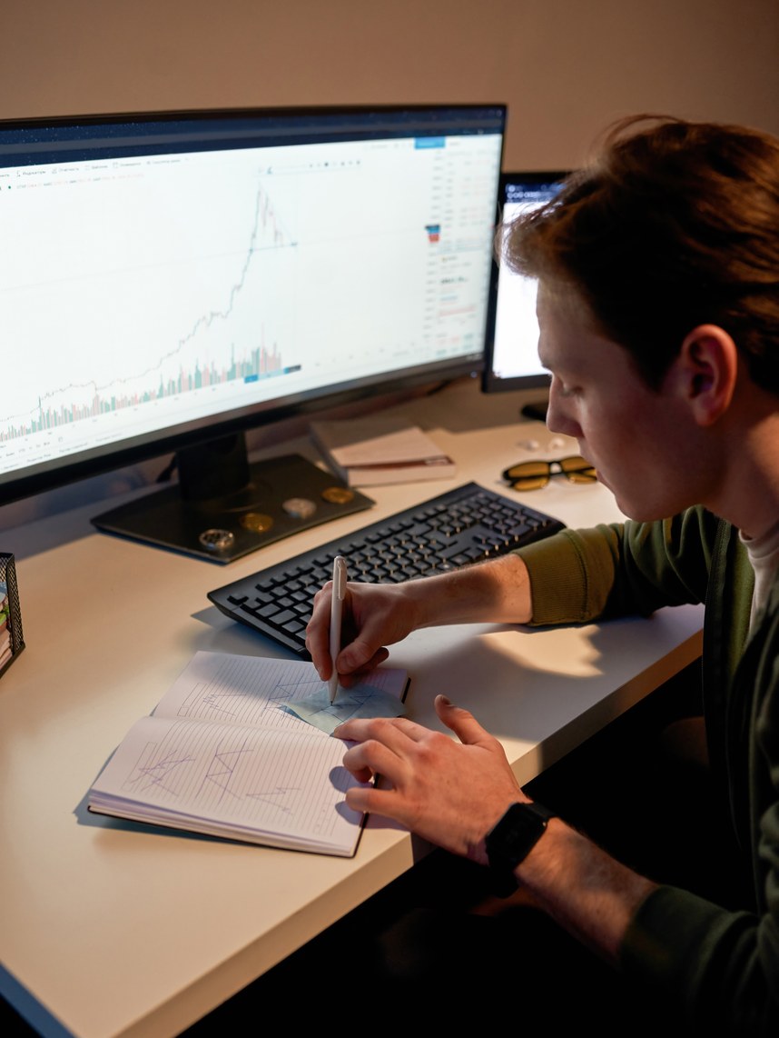 Trader estudiando un gráfico y tomando notas.