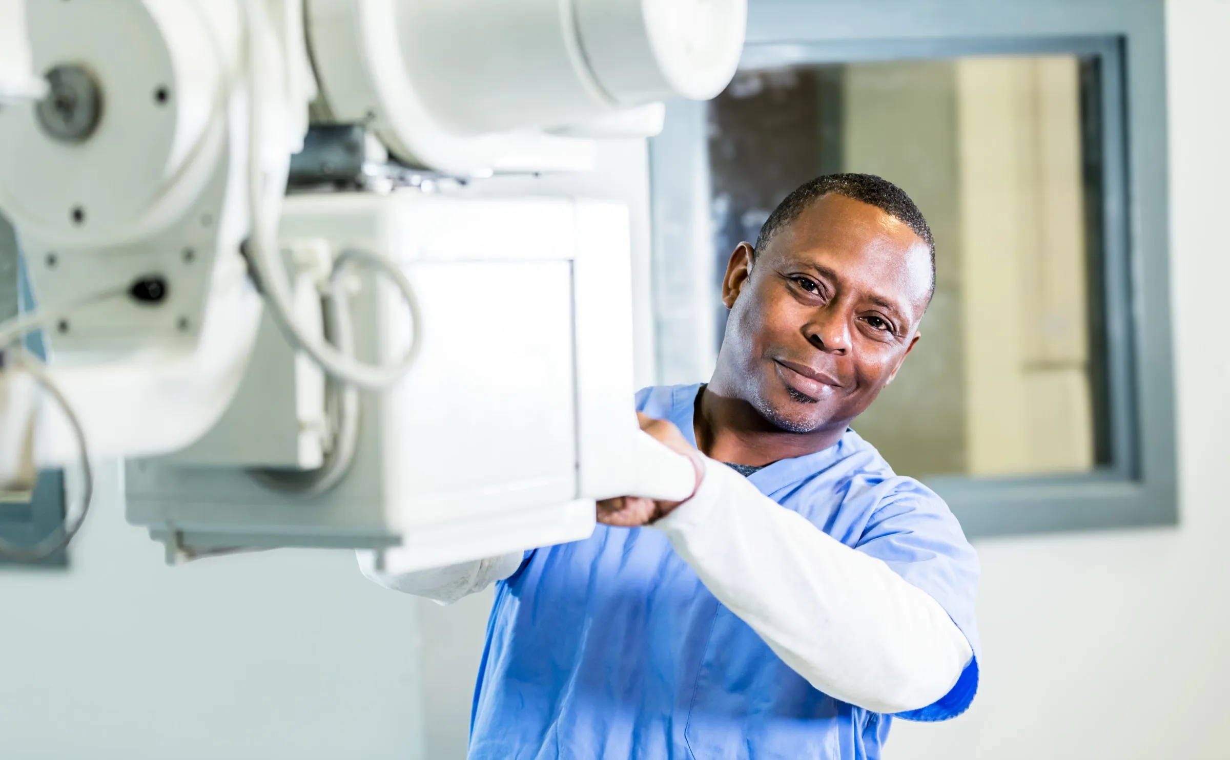 Radiologic technologist beside an X-ray machine