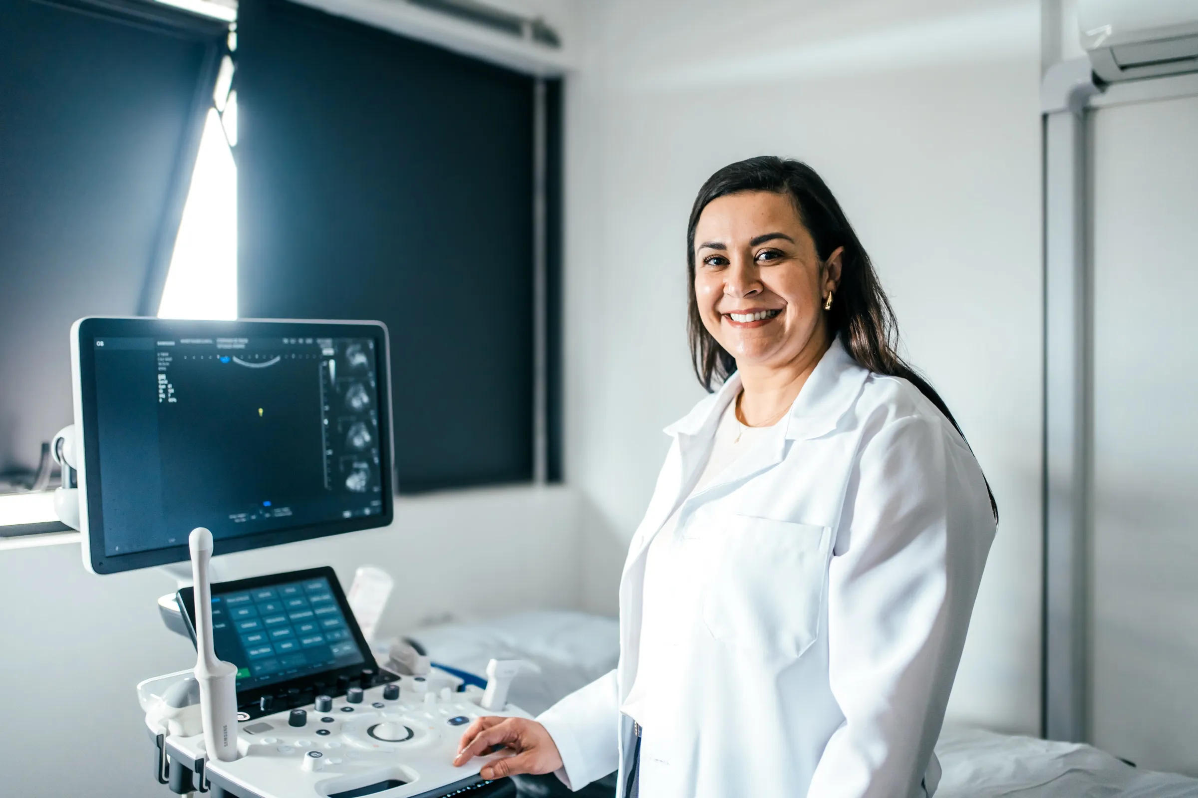 Sonographer beside an ultrasound machine