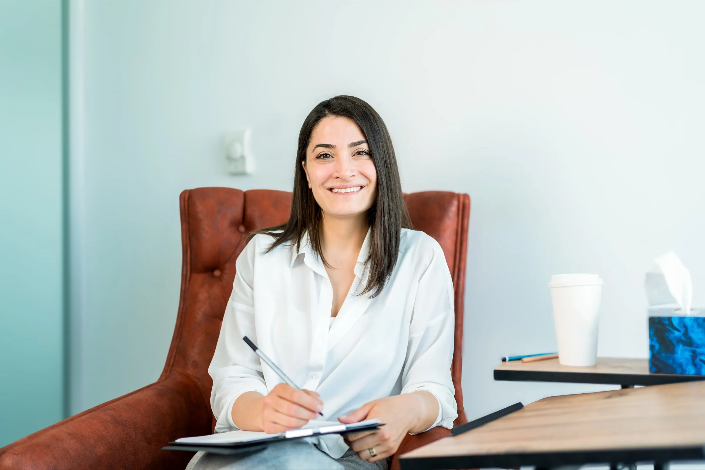 Allied health professional taking notes at a desk