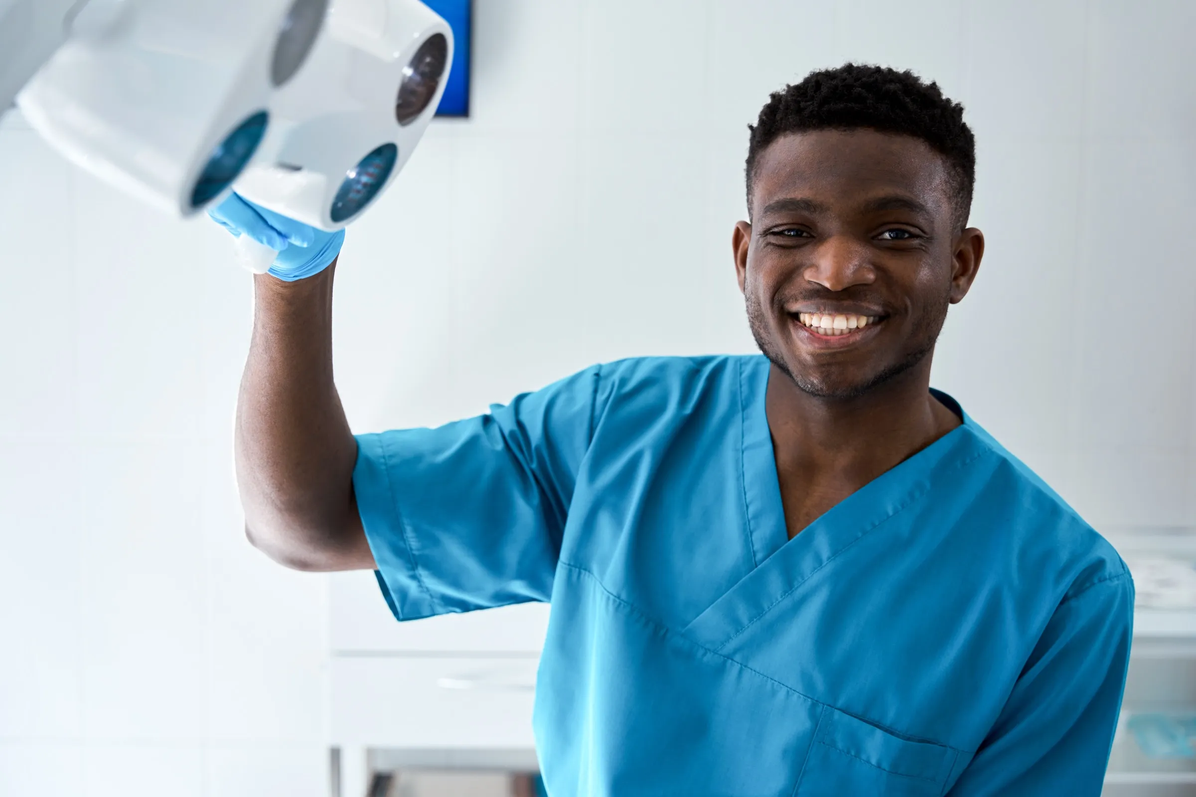 Dentist adjusting an overhead treatment light