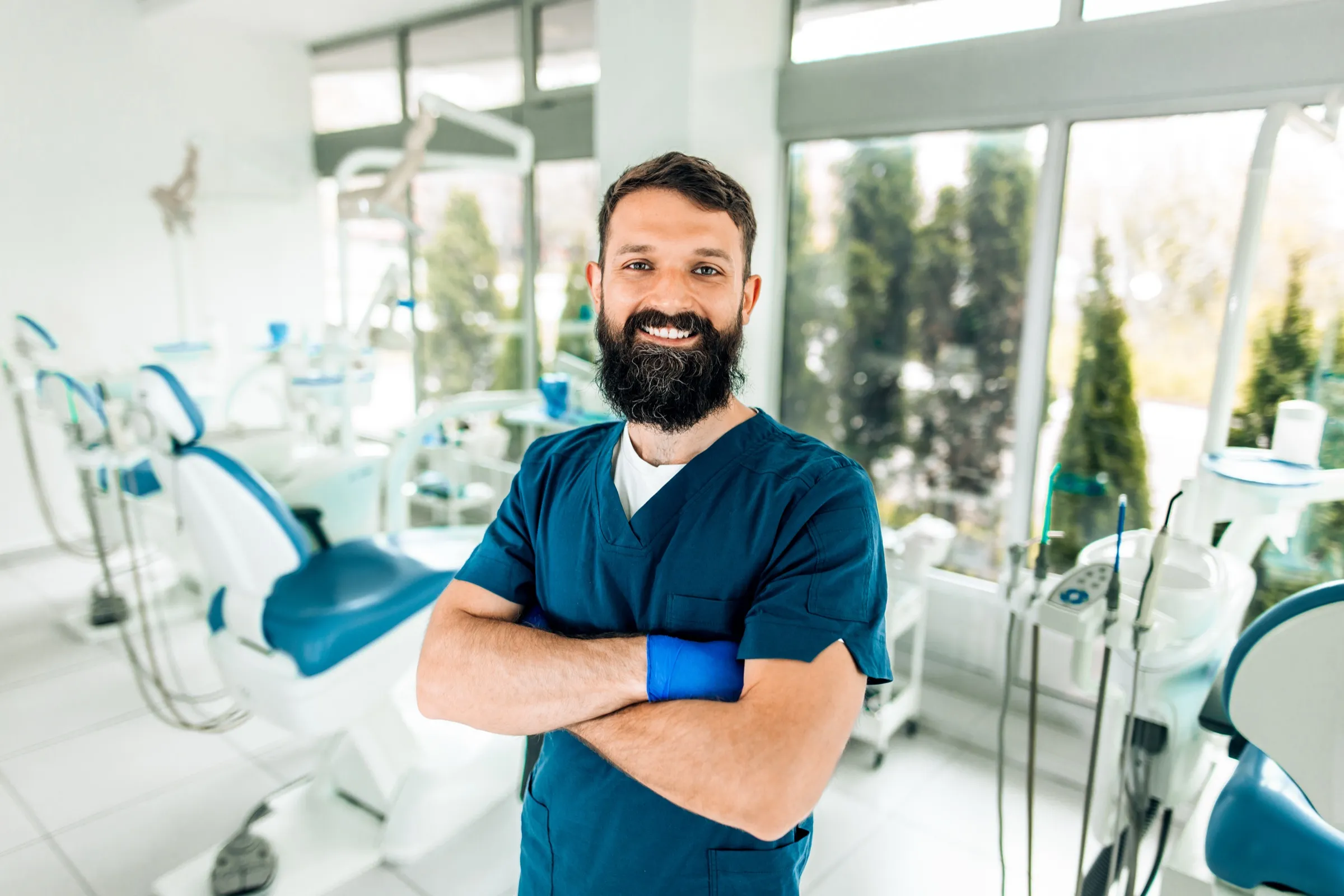 Dentist standing beside a dental chair in a modern clinic