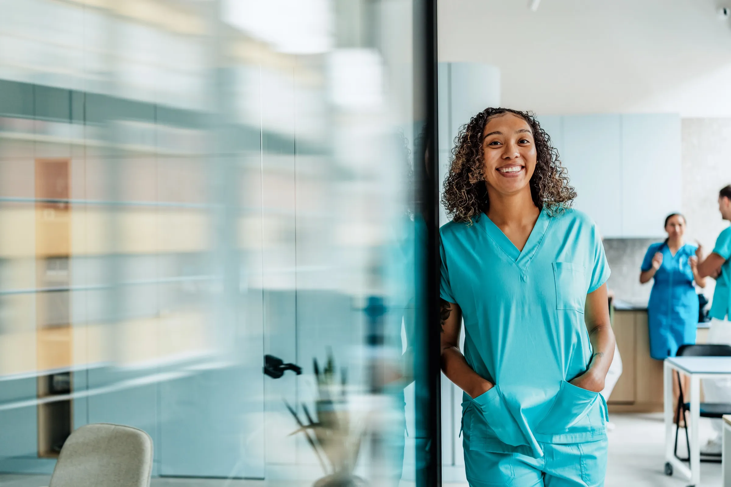 Nurse in scrubs standing in a hospital corridor