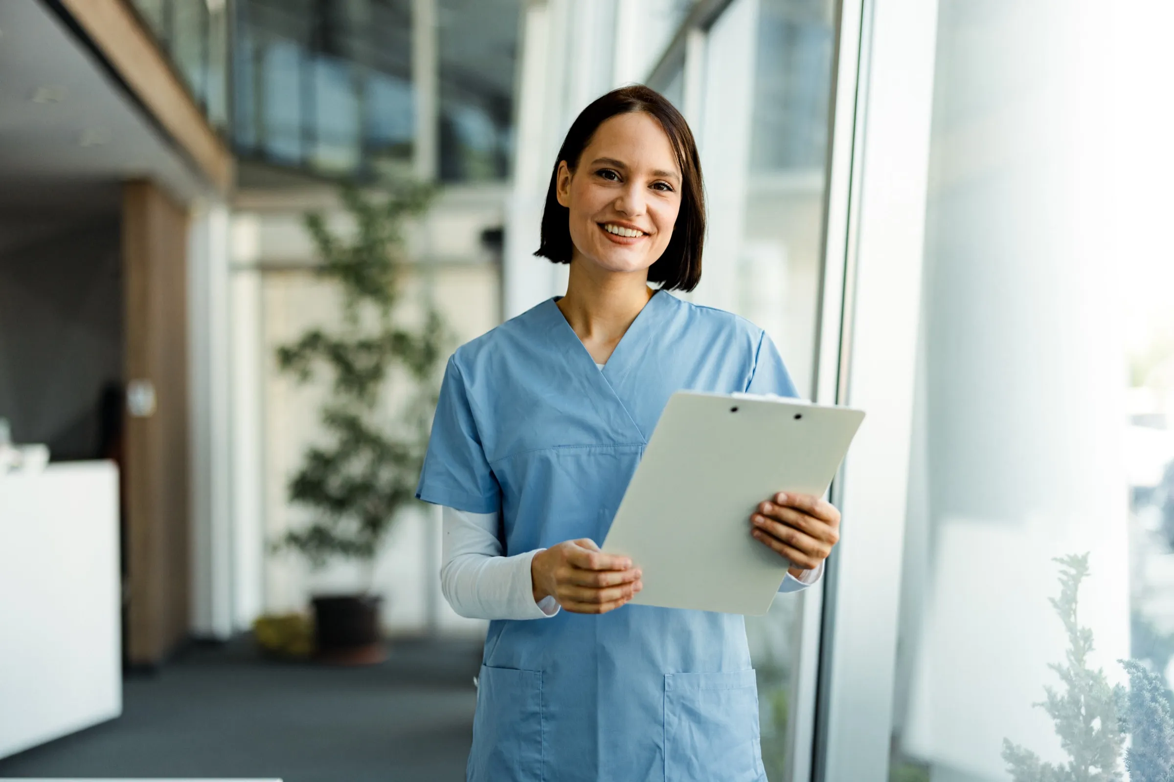 Nurse holding a patient chart in a hospital lobby