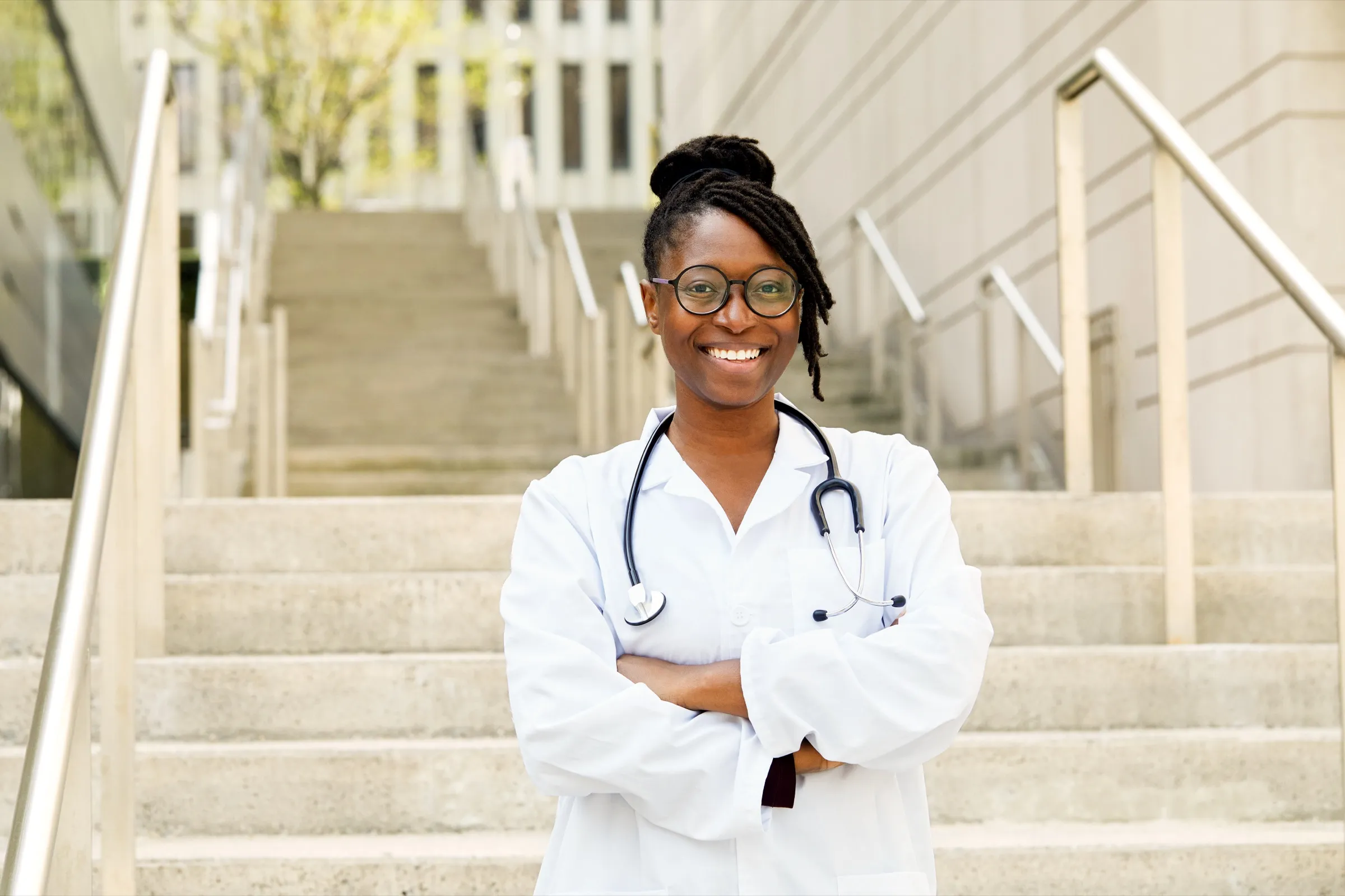 Physician standing on the stairs of a medical building