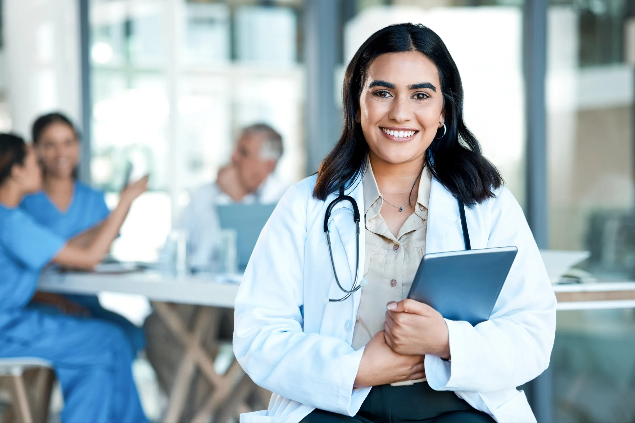 Physician holding a folder during a team meeting