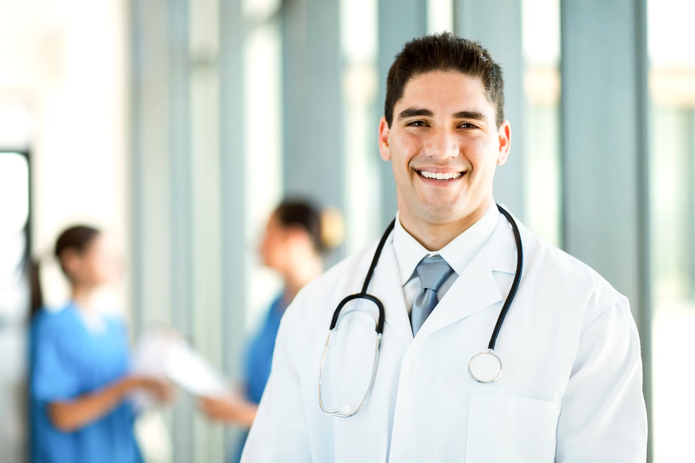 Physician standing in a busy hospital ward