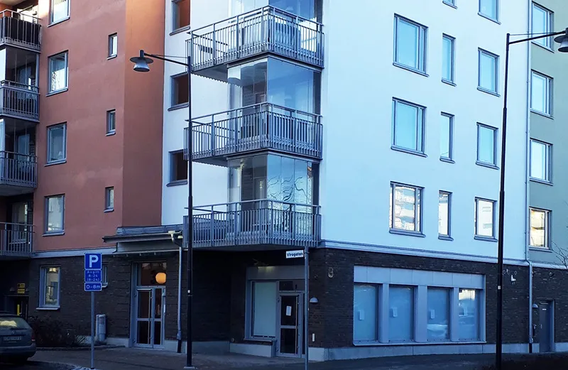 Modernt flerbostadshus i orange, vitt och blått som Sweax underhållsplanerar.