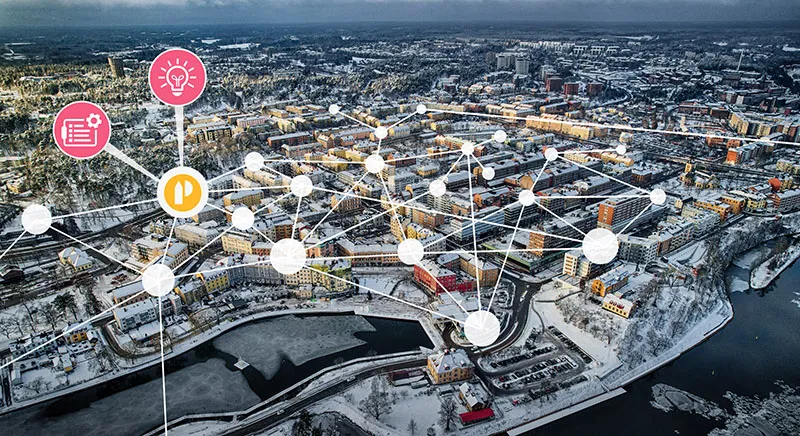 Flygbild över en stad med ett nätverk av sammankopplade byggnader som symboliserar datadriven fastighetsanalys
