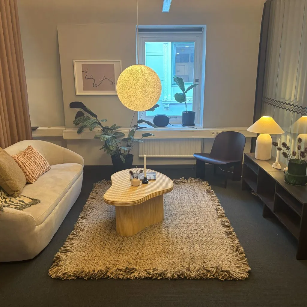 Mysig sittgrupp med soffa och rund taklampa i Planimas nya kontor
