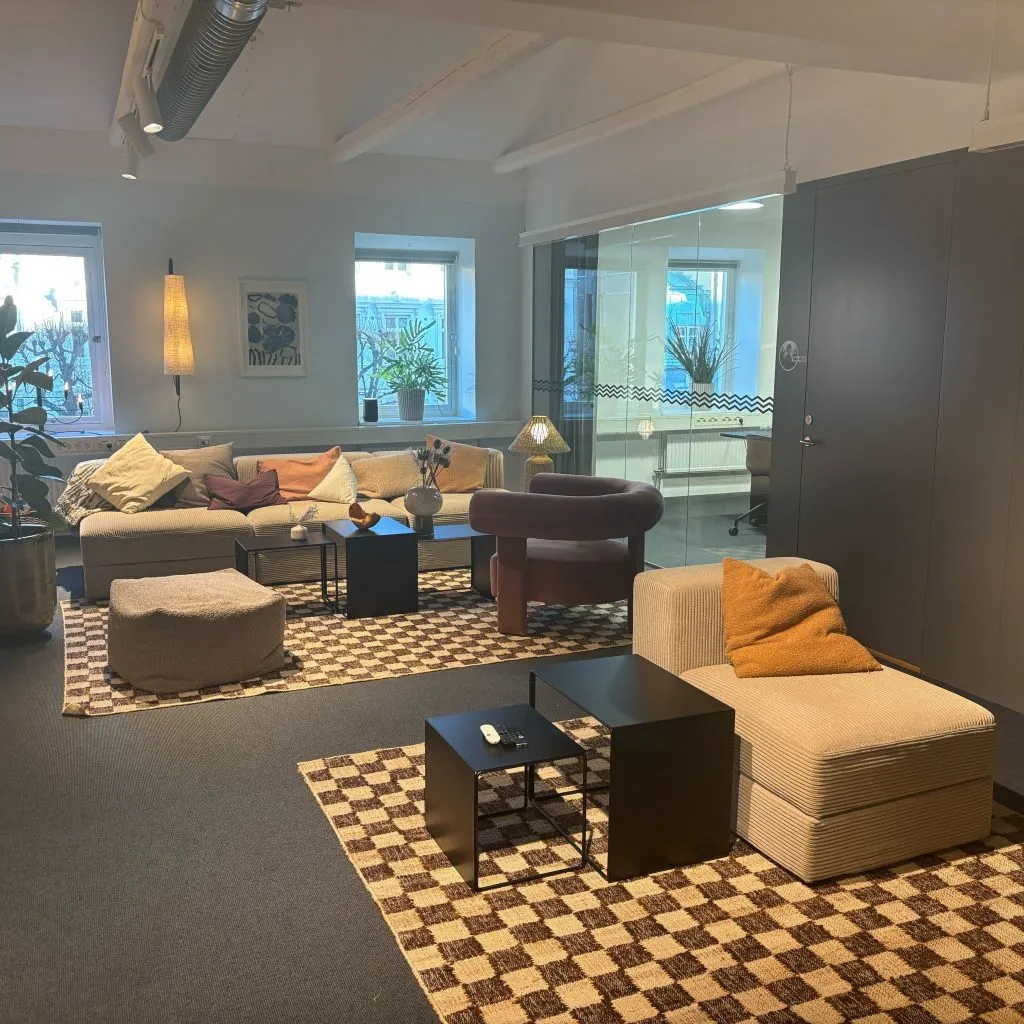 Loungeyta med soffor och mönstrade mattor i Planimas nya kontor