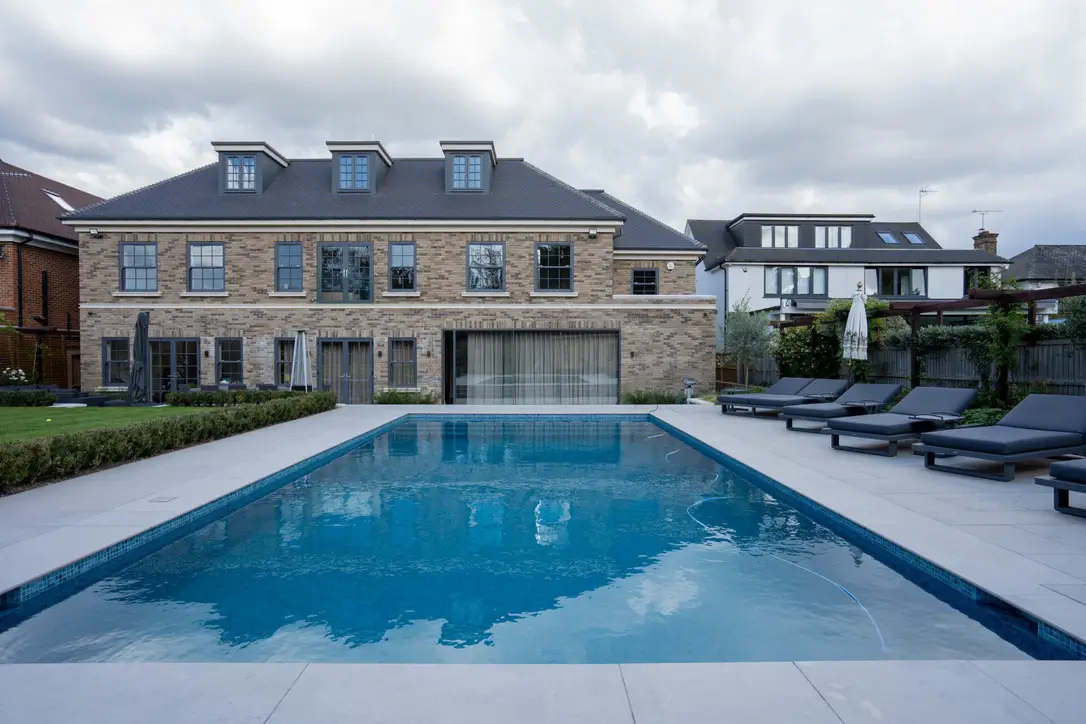 the rear exterior of a luxury modern-Georgian style two-story brick house featuring dormer windows