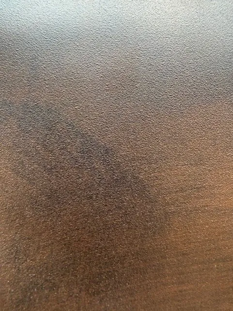 Close-up of a brown textured surface with some darker and lighter areas.