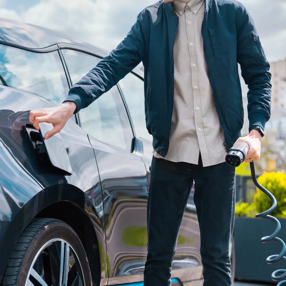 Uomo che sta mettendo in carica l'auto elettrica