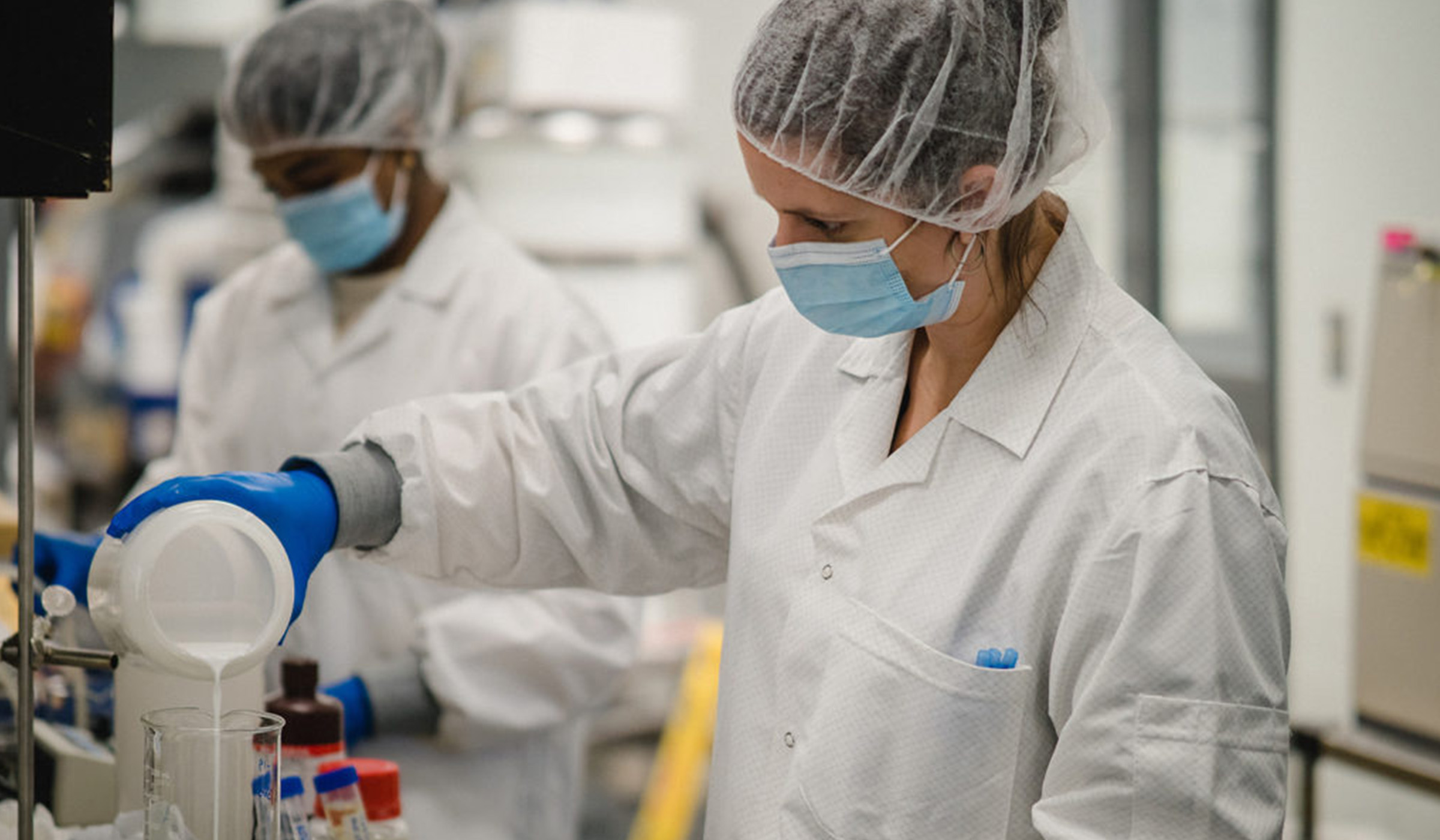 Scientist pouring Skelite into a glass beaker
