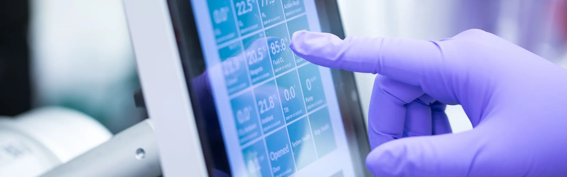 Gloved hand using the Cocoon Platform touchscreen.