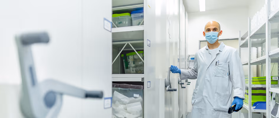 Masked technician opens a storage cabinet in the cleanroom