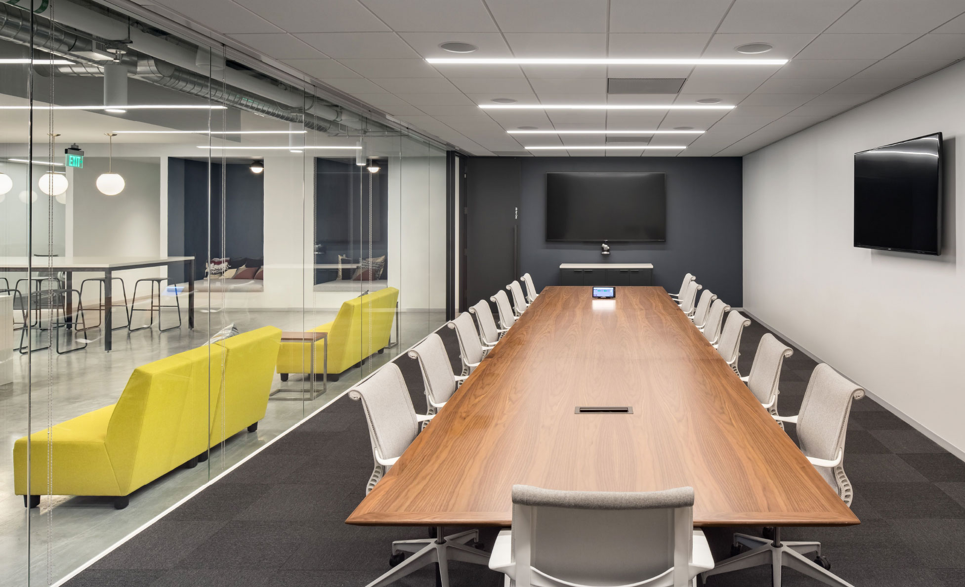 Conference room with a long table and video displays