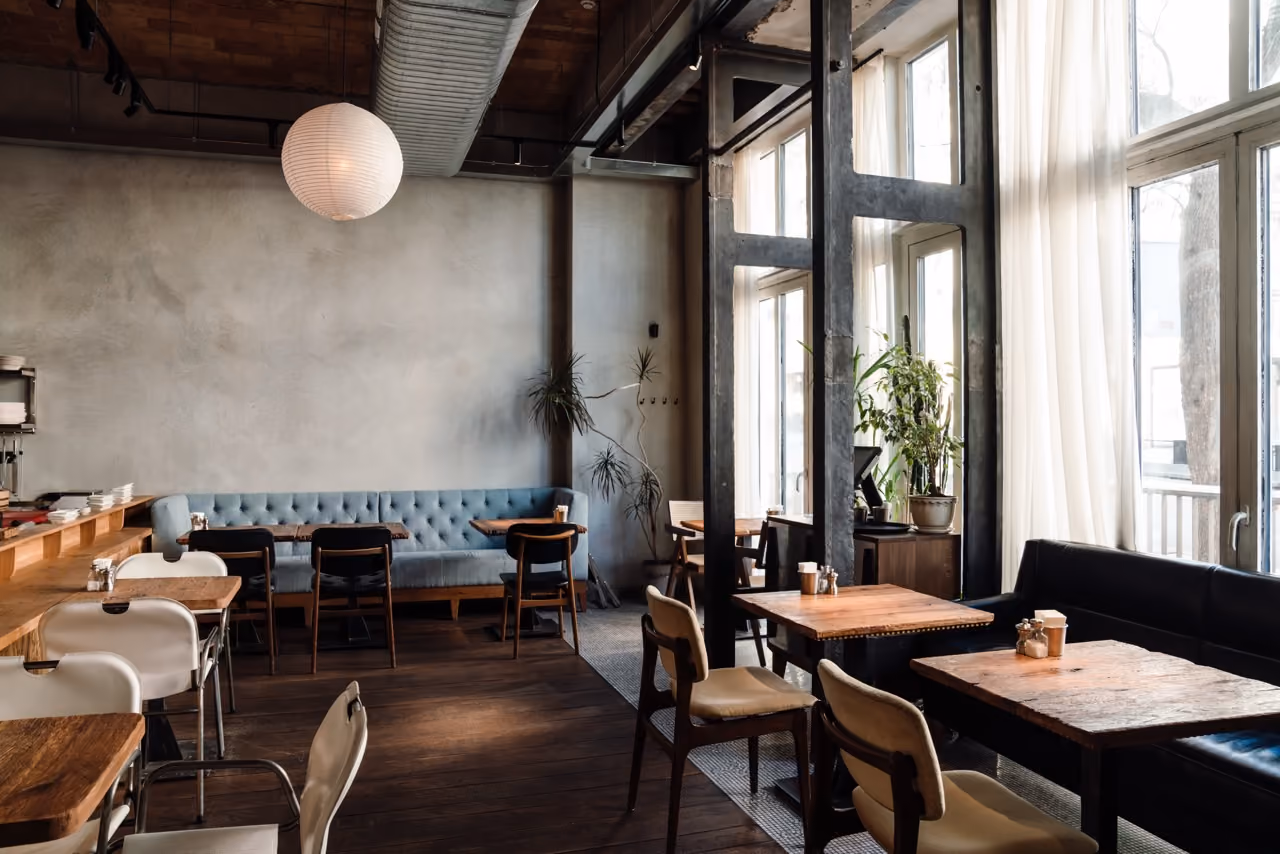 A restaurant with a blue couch and a white tablecloth.