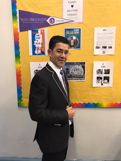 Staff member standing in front of school bulletin board