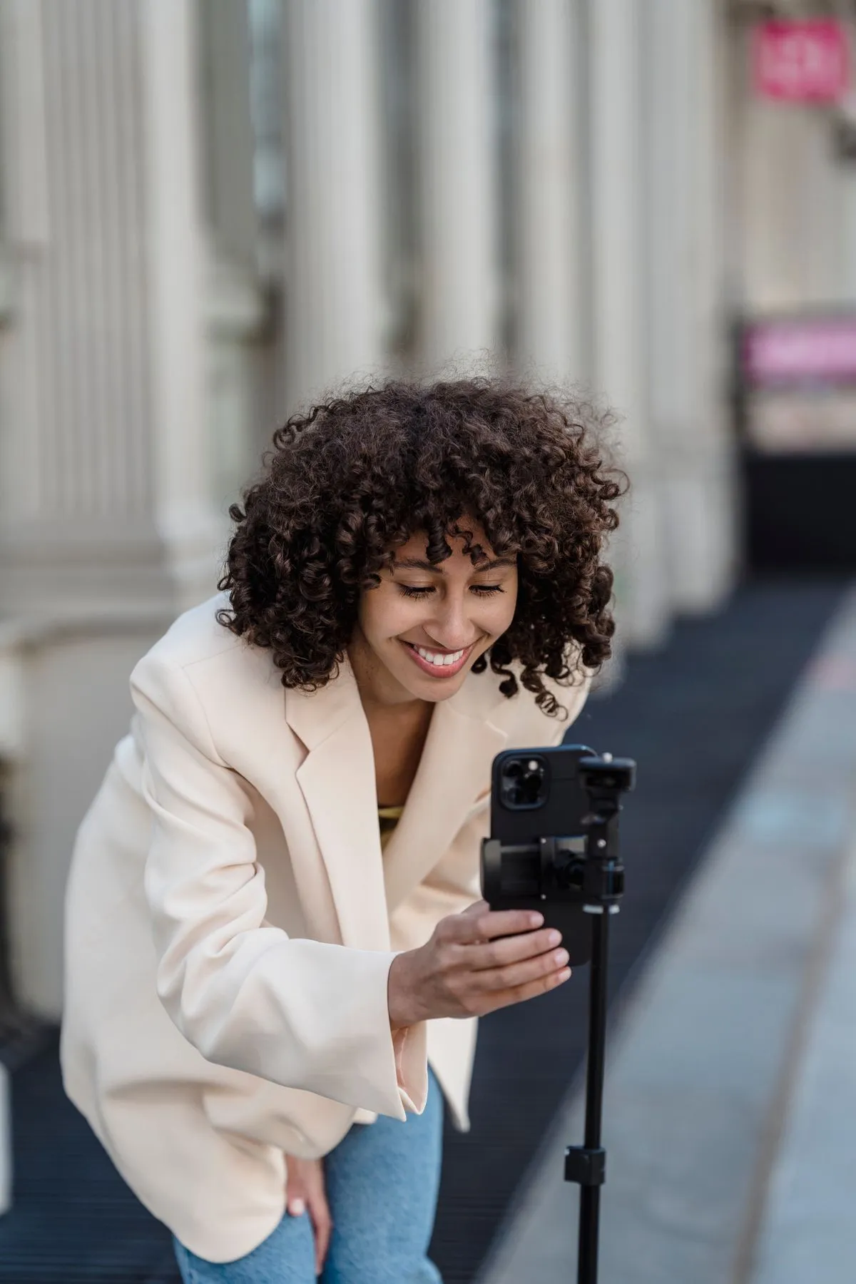 Une jeune femme filme avec son smartphone dans la rue