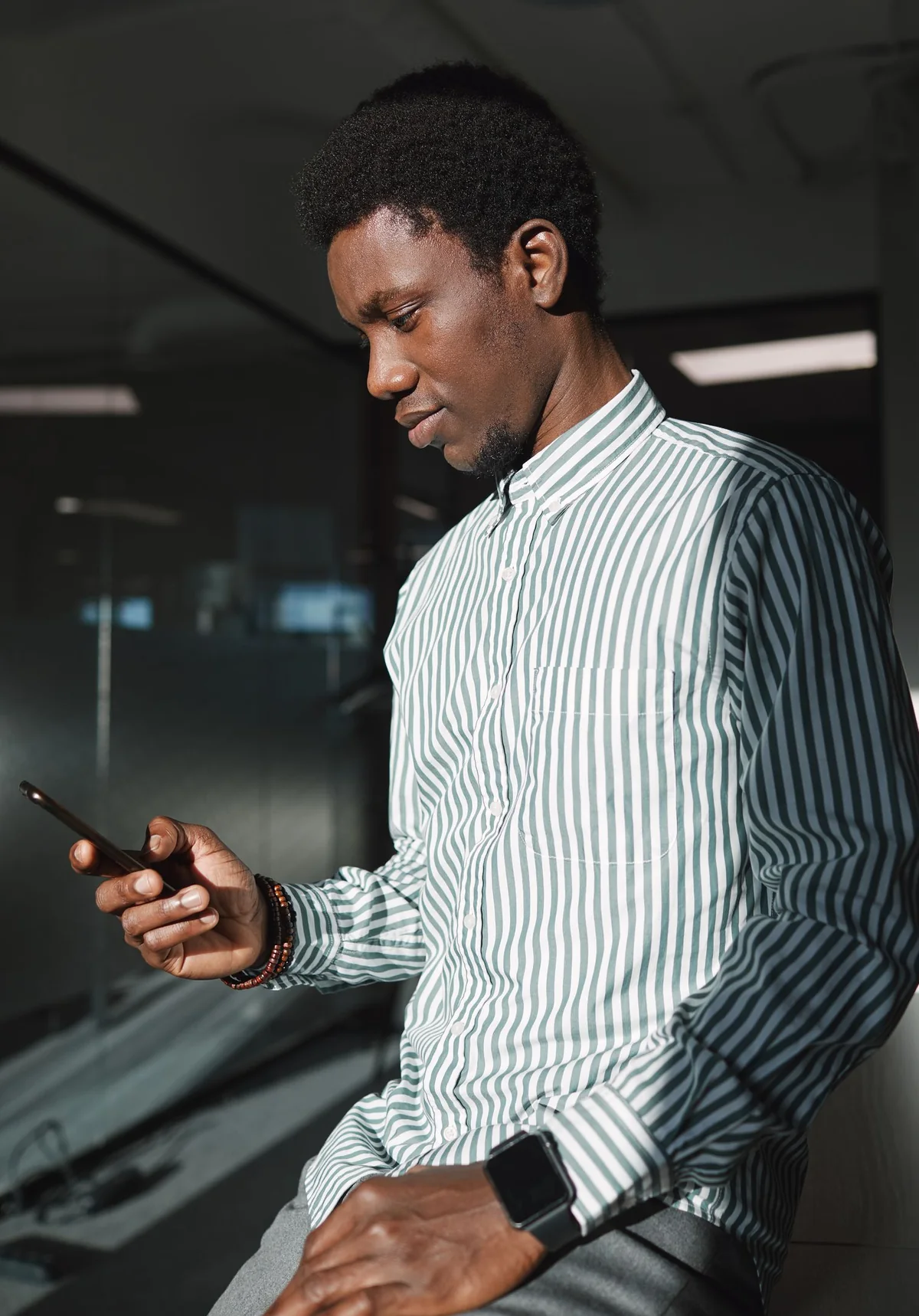 Un conseiller lit un message WhatsApp sur son smartphone, au bureau